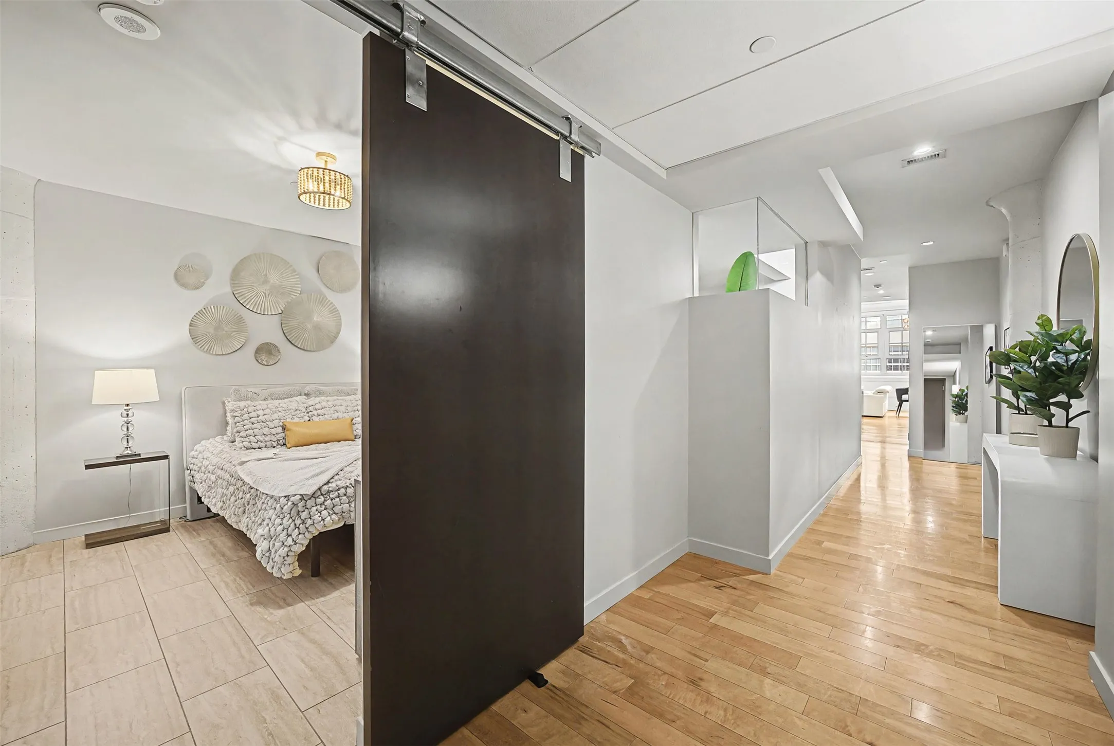 Hall with a barn door and light wood-type flooring
