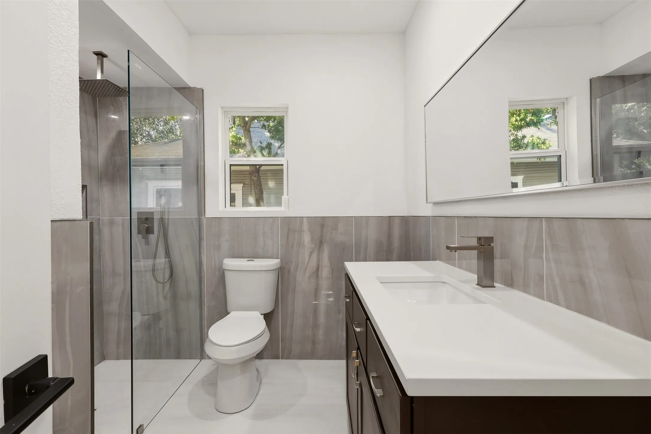 Walk-in shower with glass enclosure and rain-style showerhead