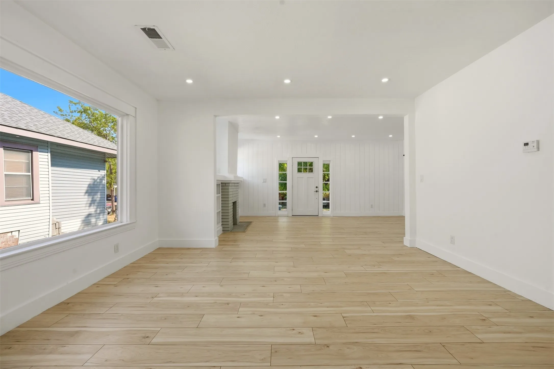 Spacious interior with wood-finish flooring, recessed lighting, and a prominent picture window