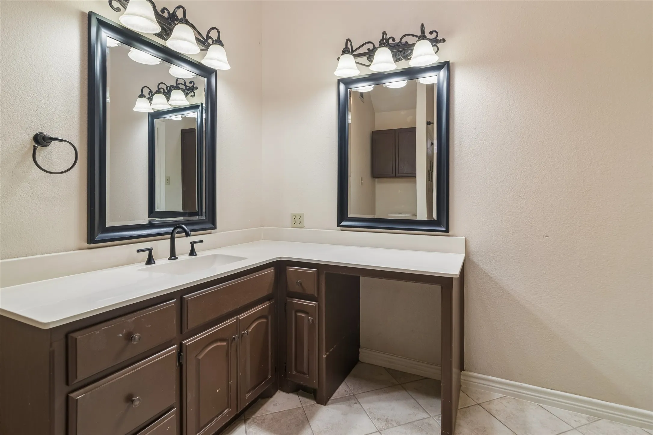 Dual vanity with integrated sinks, dark wood-finish cabinetry, and white countertops