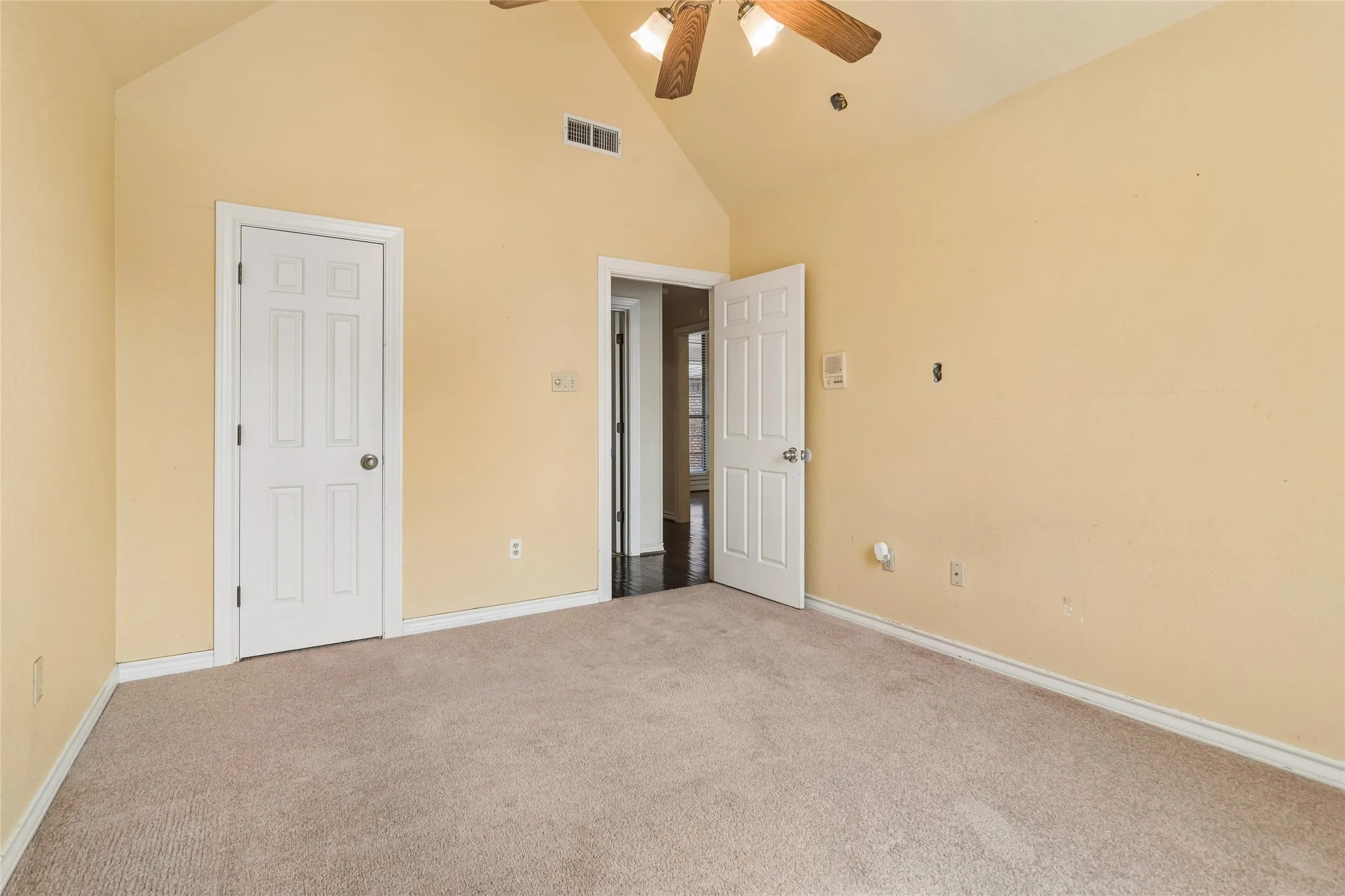 Vaulted ceiling, carpeted flooring, walk-in closet and a ceiling fan