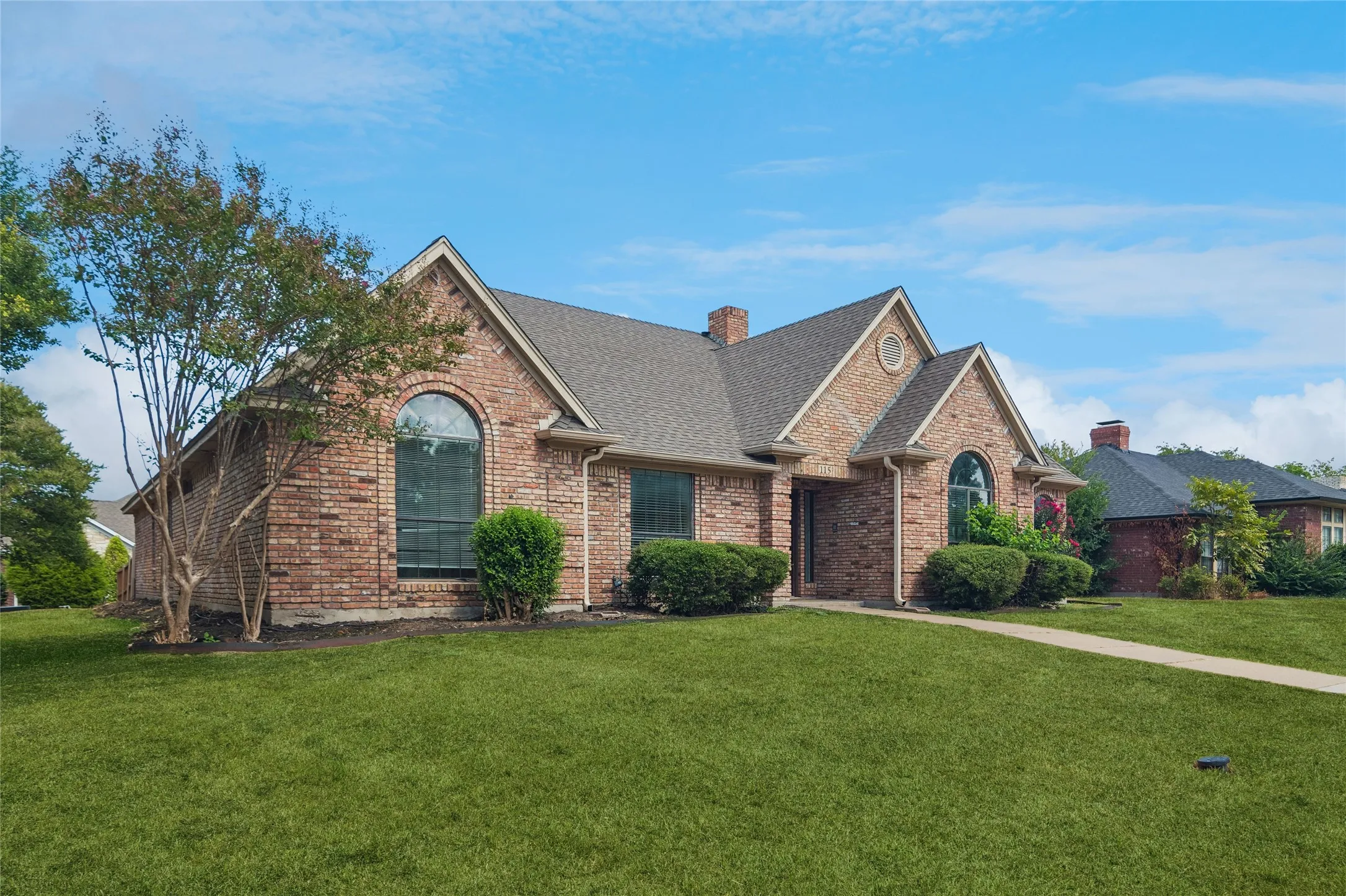 Brick exterior with multiple gables and arched windows