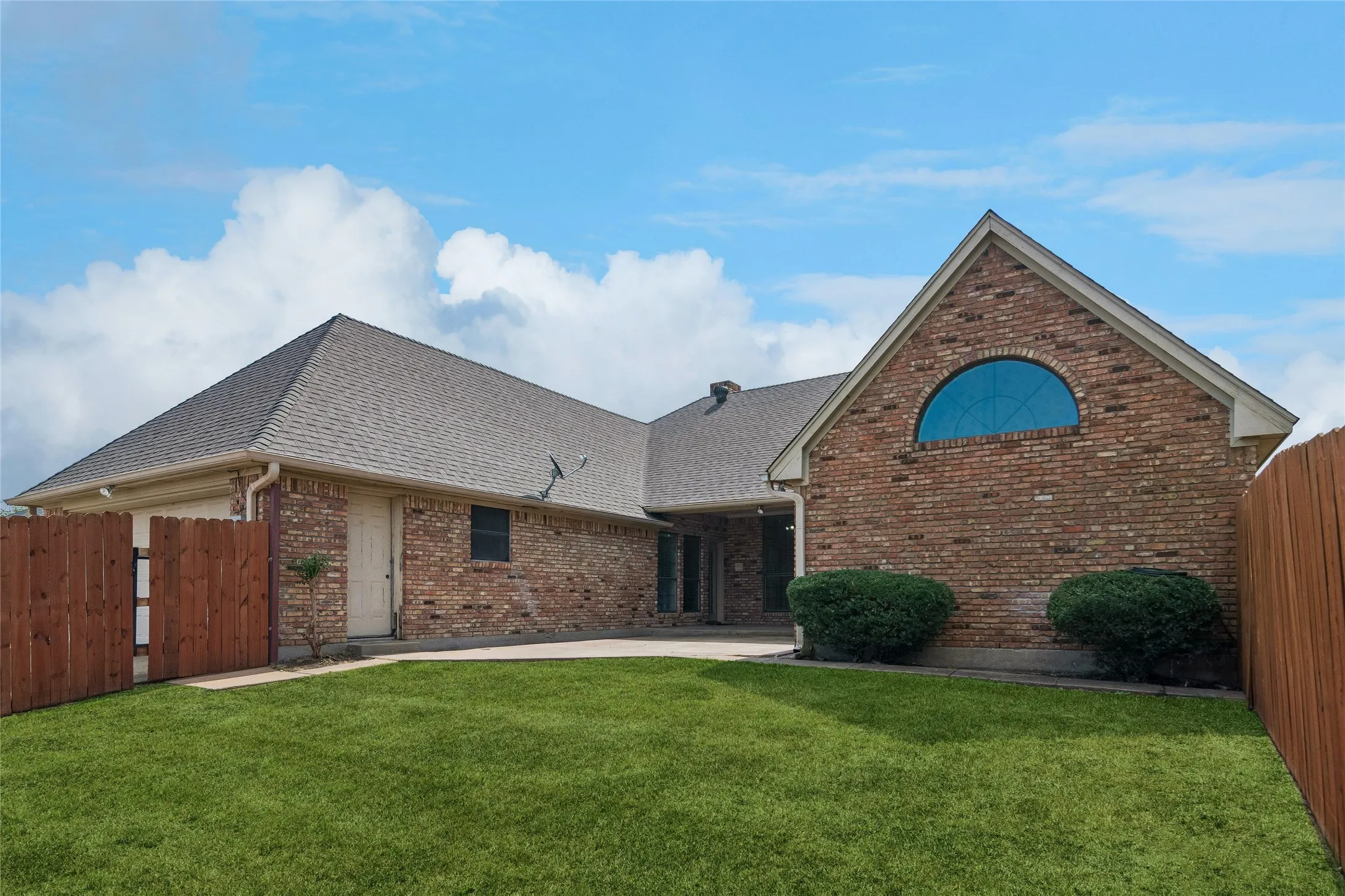 Brick exterior with a prominent arched window and a gable roofline