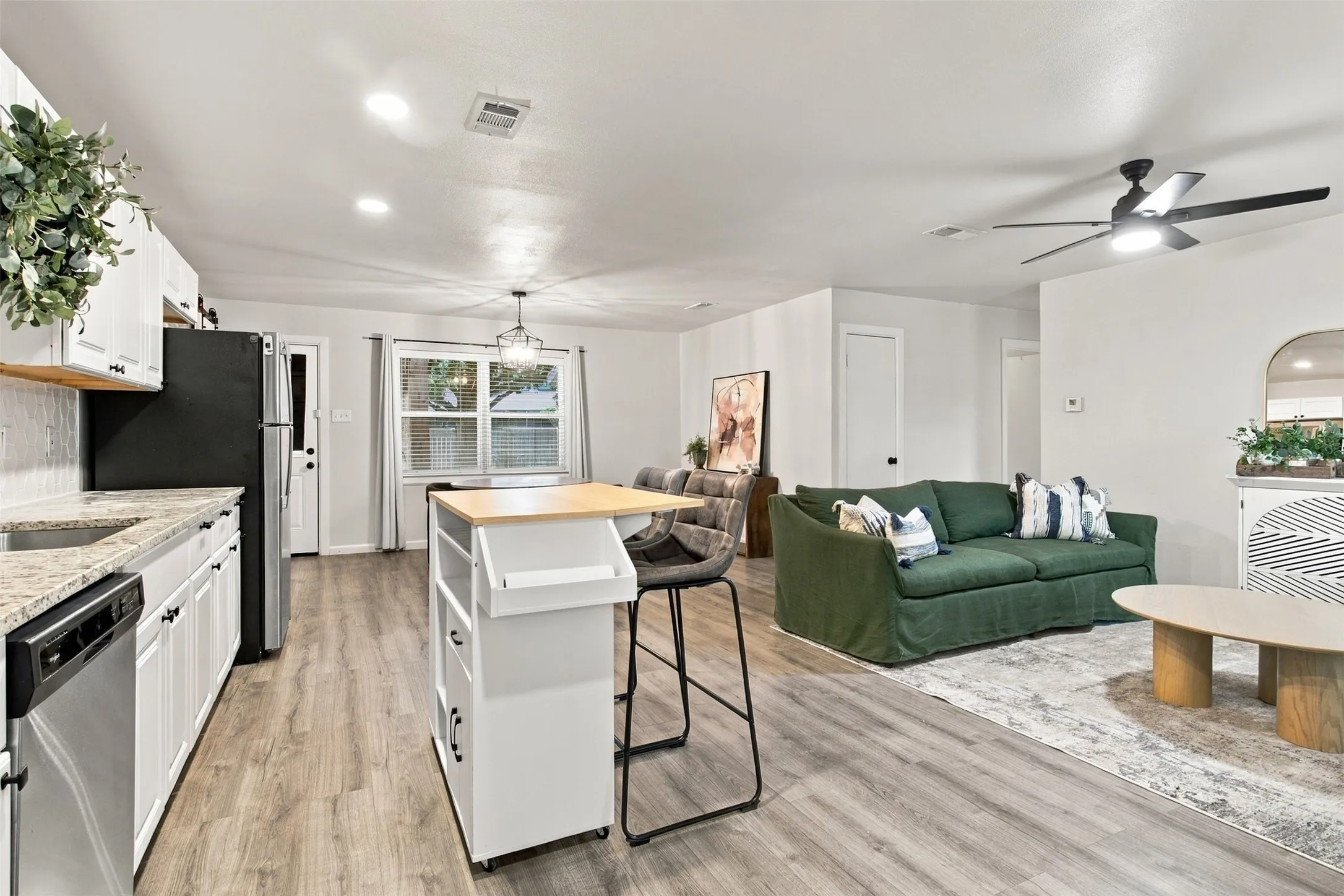 Open-concept living area featuring wood-finish flooring, recessed lighting, and a ceiling fan