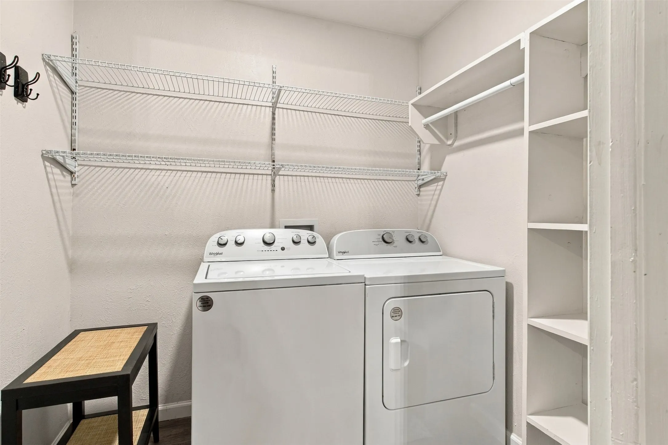 Equipped laundry space featuring a washer and dryer, wire shelving, and built-in shelving with a hanging rod