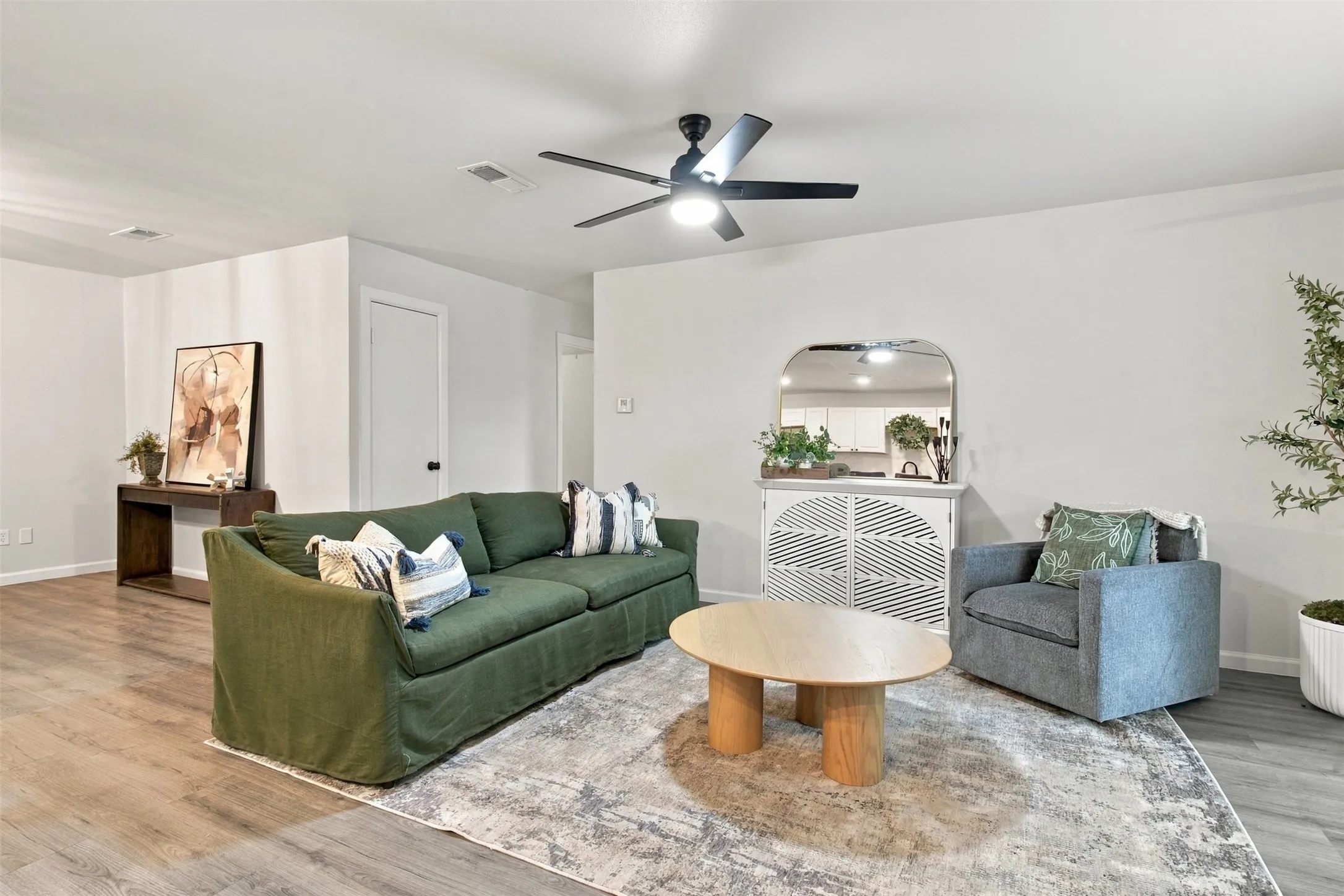 Recessed lighting, wood-finish flooring, and a ceiling fan with integrated lighting
