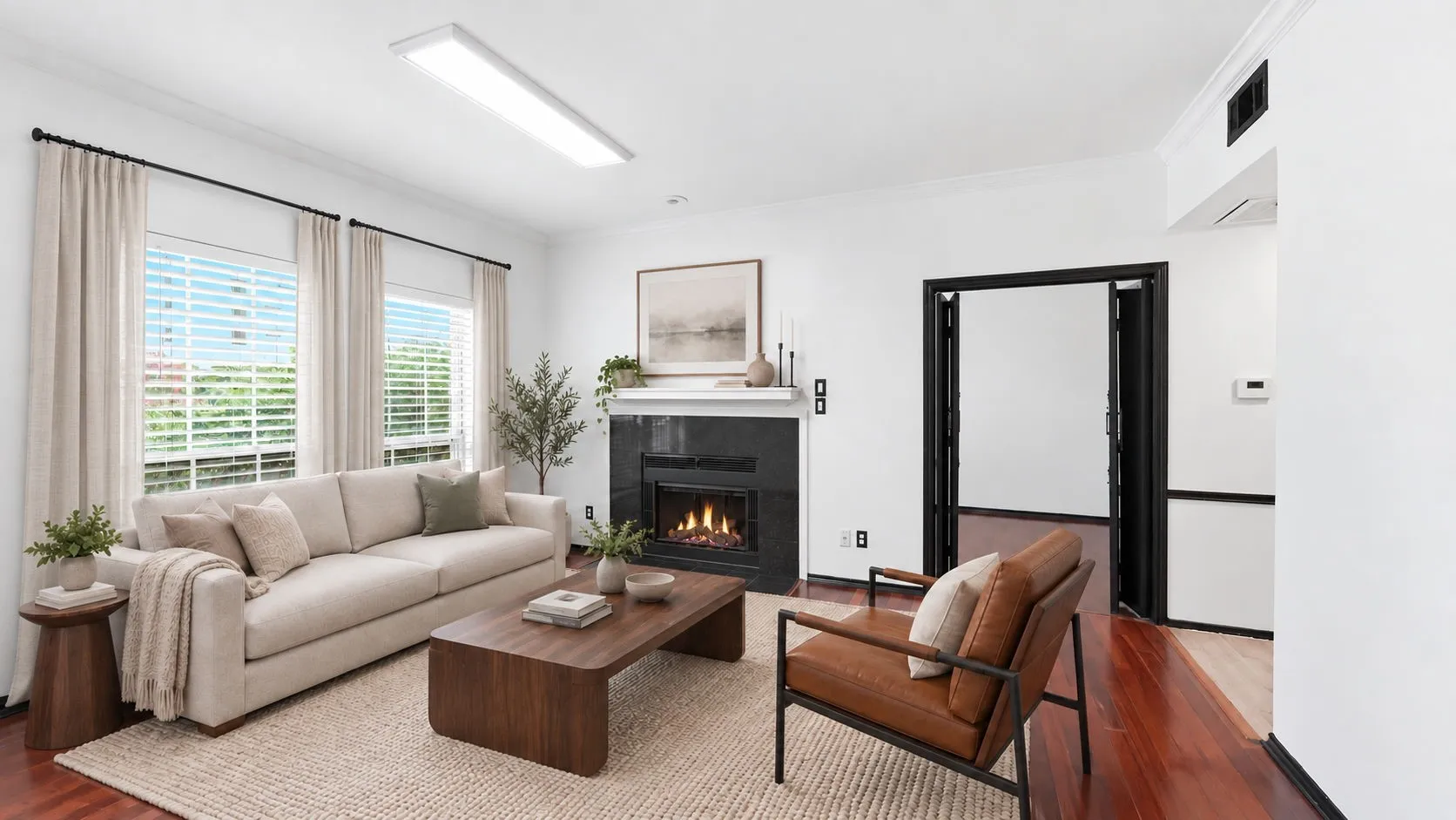Fireplace with a black stone surround and white mantel Virtually staged