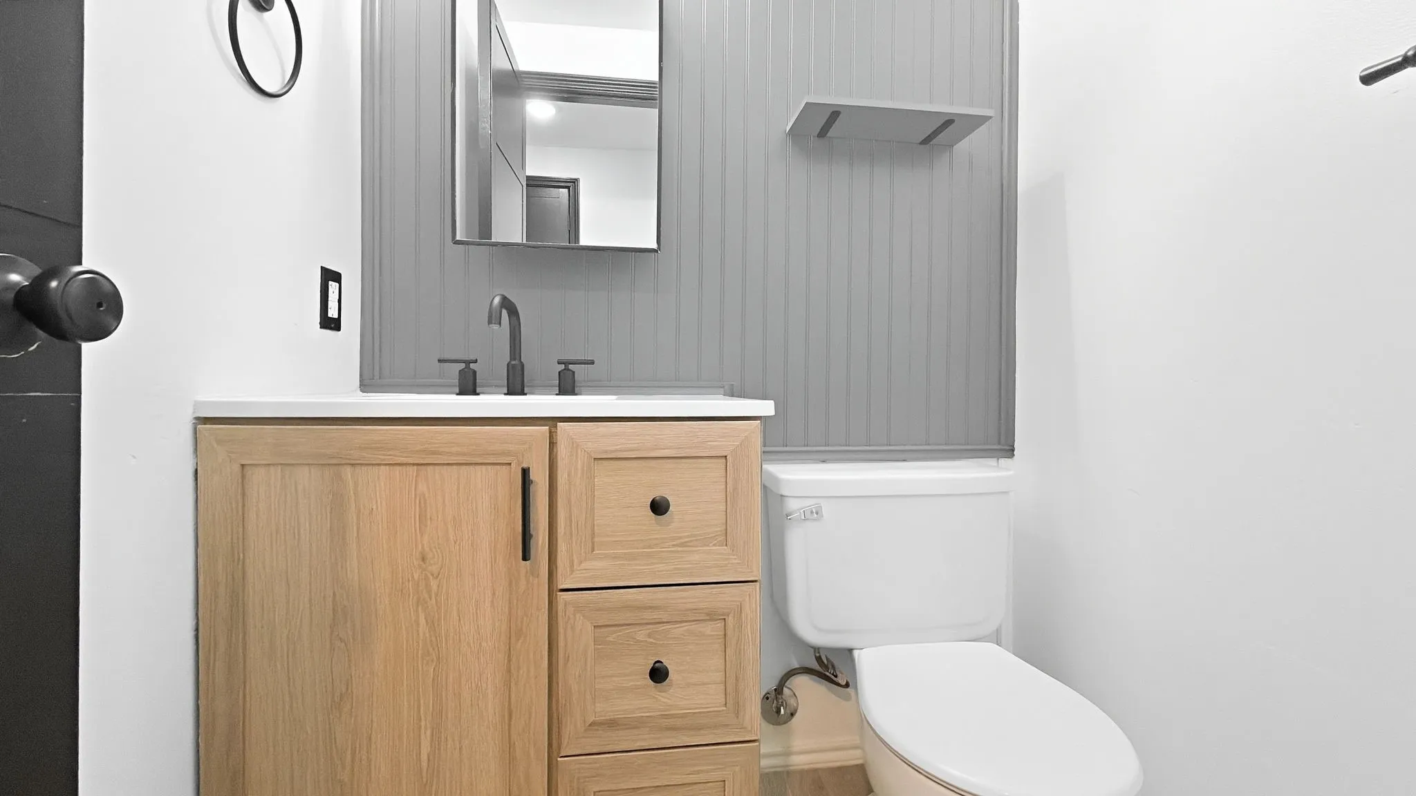 Vanity with a light wood-finish cabinet and white countertop