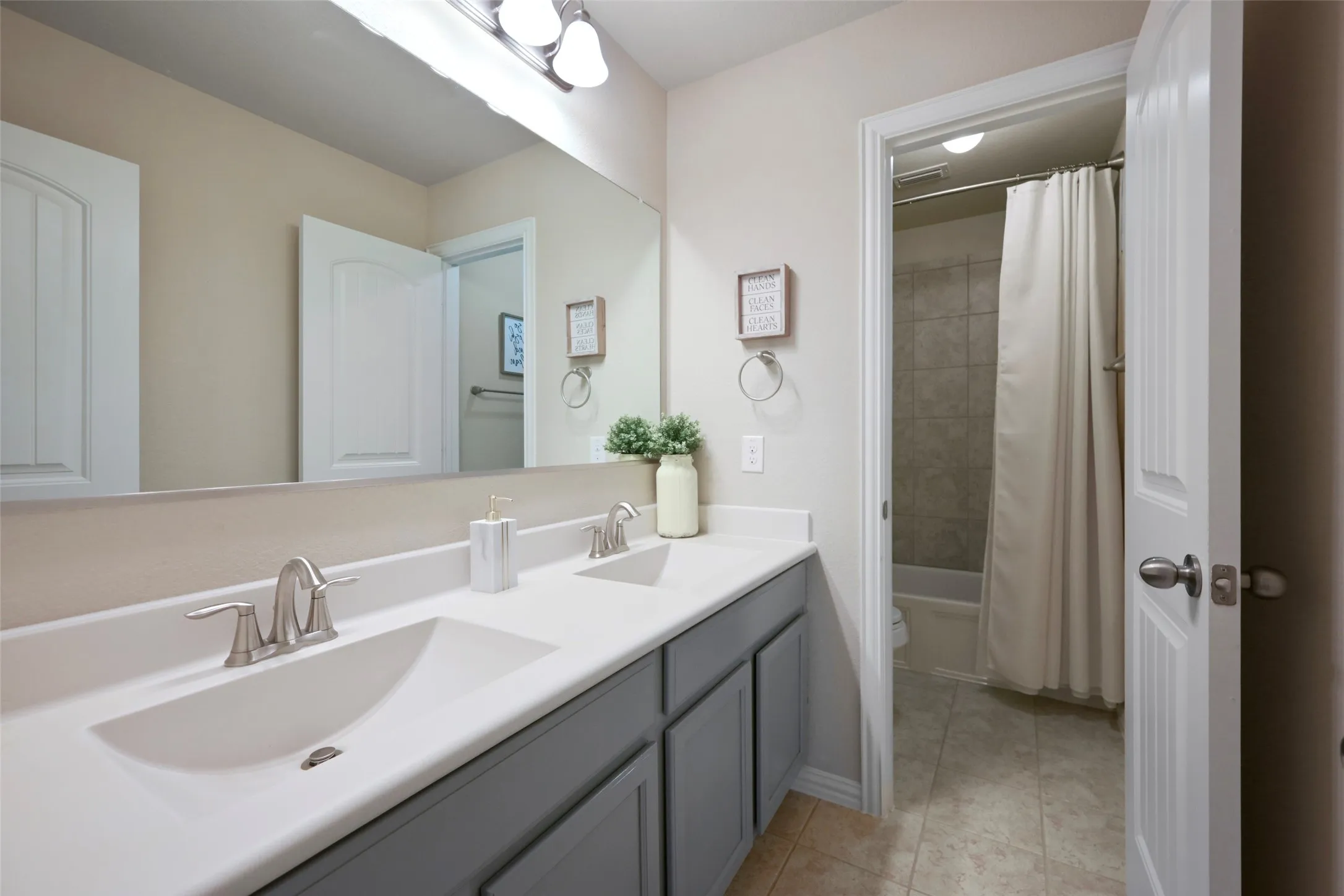 Dual vanity with integrated sinks, brushed nickel faucets, and under-cabinet storage