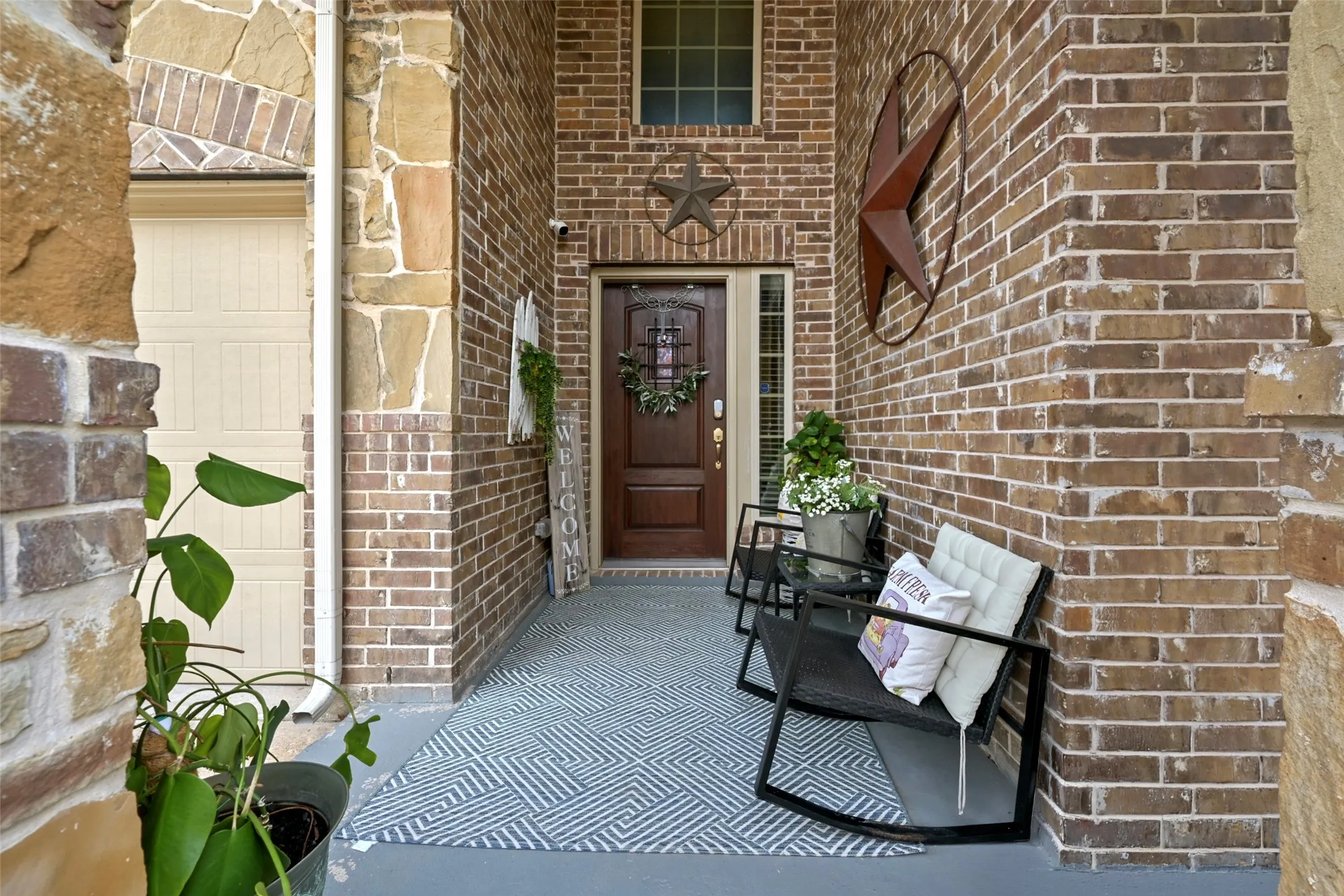 Brick and stone exterior with a dark wood entry door and transom window