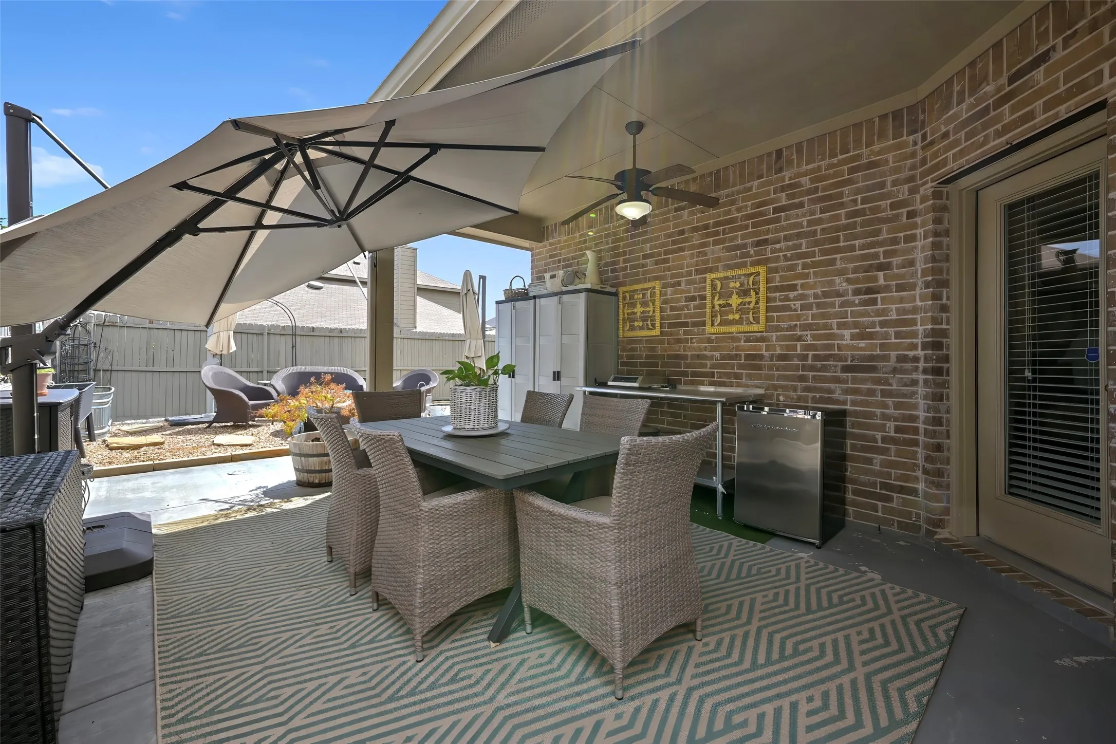 Covered patio with brick wall and ceiling fan