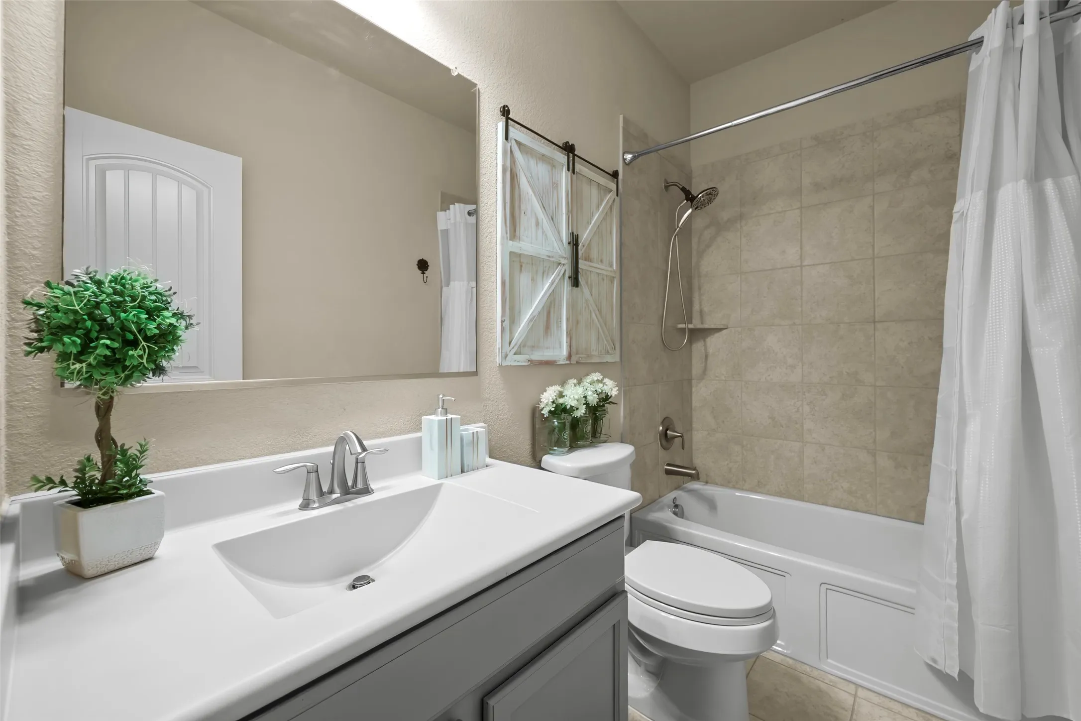Vanity with integrated sink, brushed nickel faucet, and frameless mirror