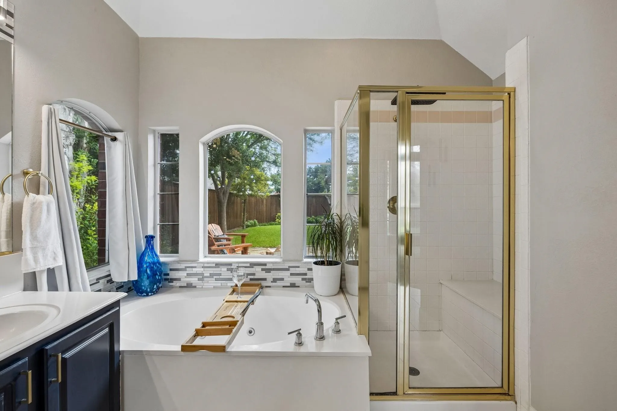 Soaking tub with a mosaic tile surround and multiple arched windows