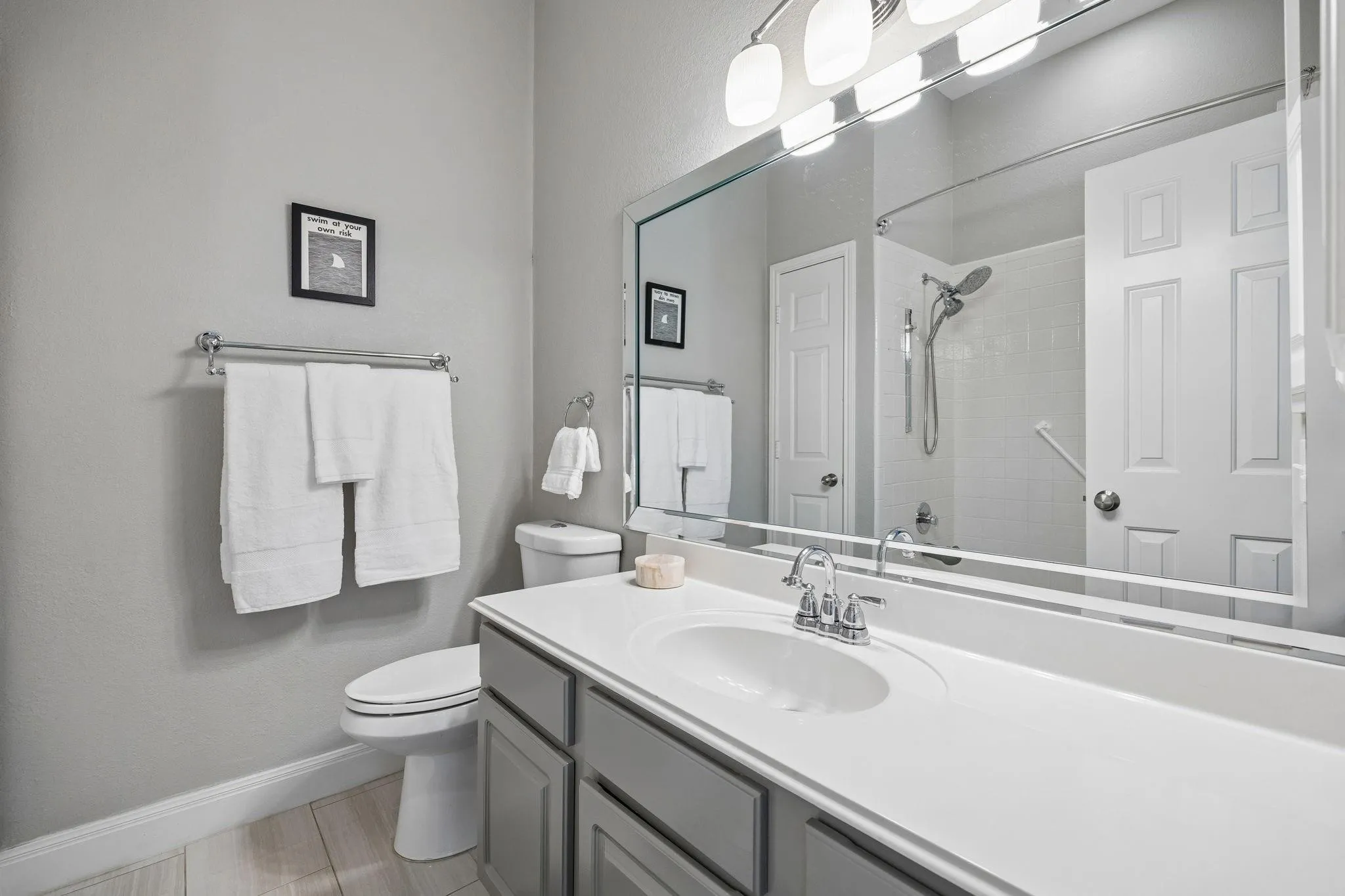Vanity with an integrated sink and chrome fixtures, ample countertop space, and lower cabinetry