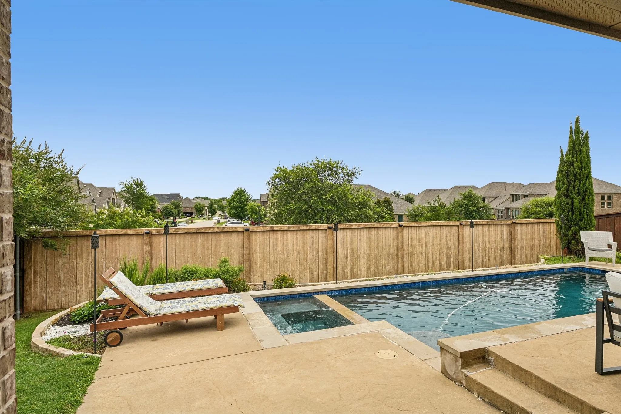 Backyard oasis featuring a swimming pool, integrated spa, and concrete patio