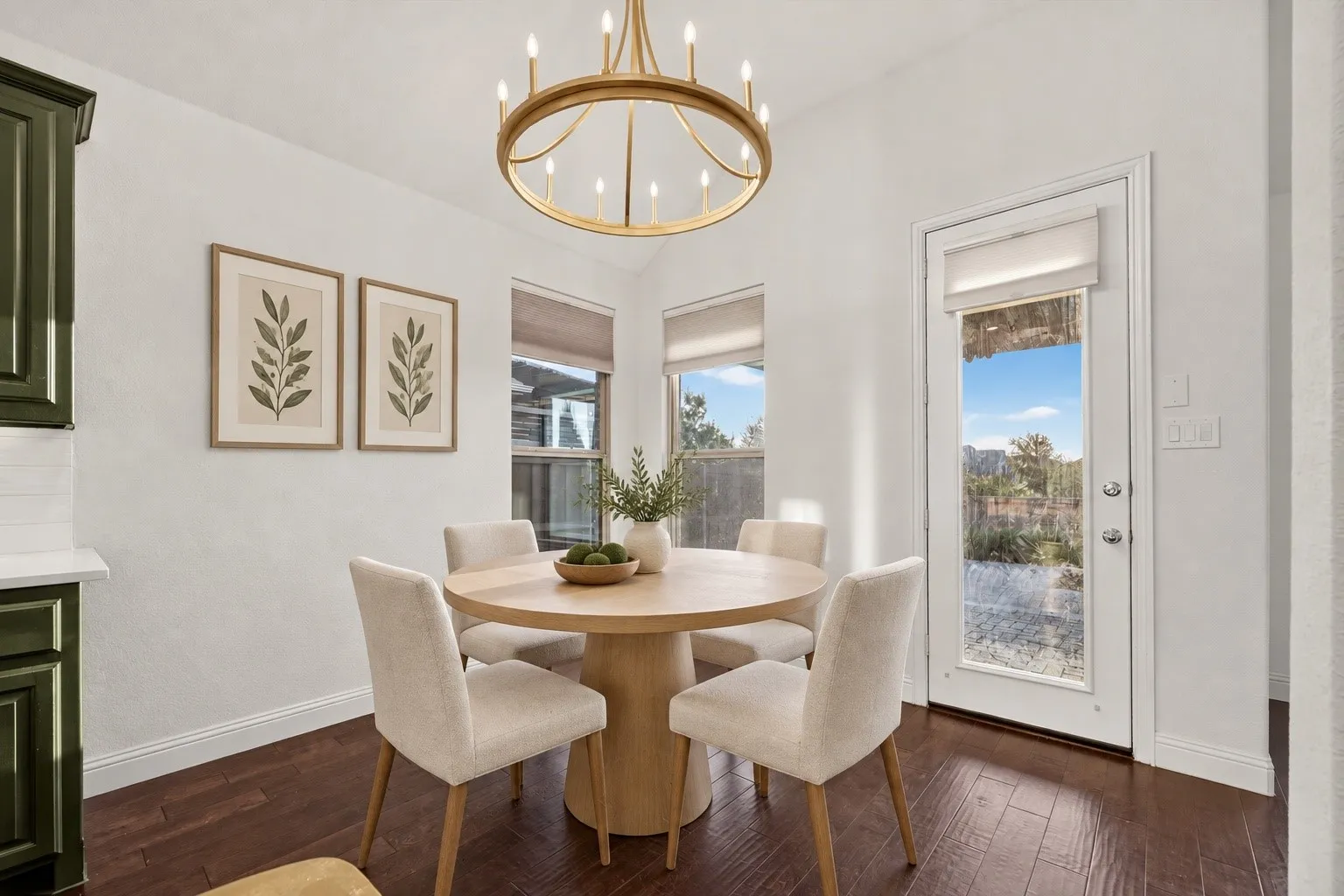 Wood-finish flooring with white baseboards, a gold-tone chandelier, and multiple windows for natural light