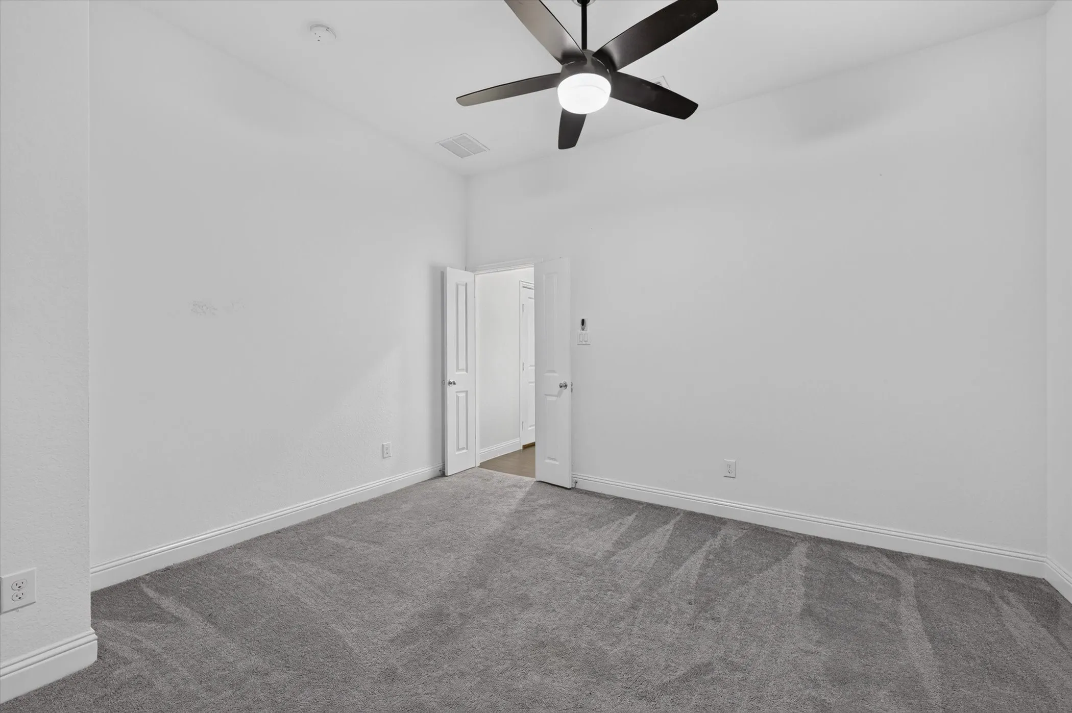 Neutral wall paint, gray carpet, white trim, and a ceiling fan with integrated lighting