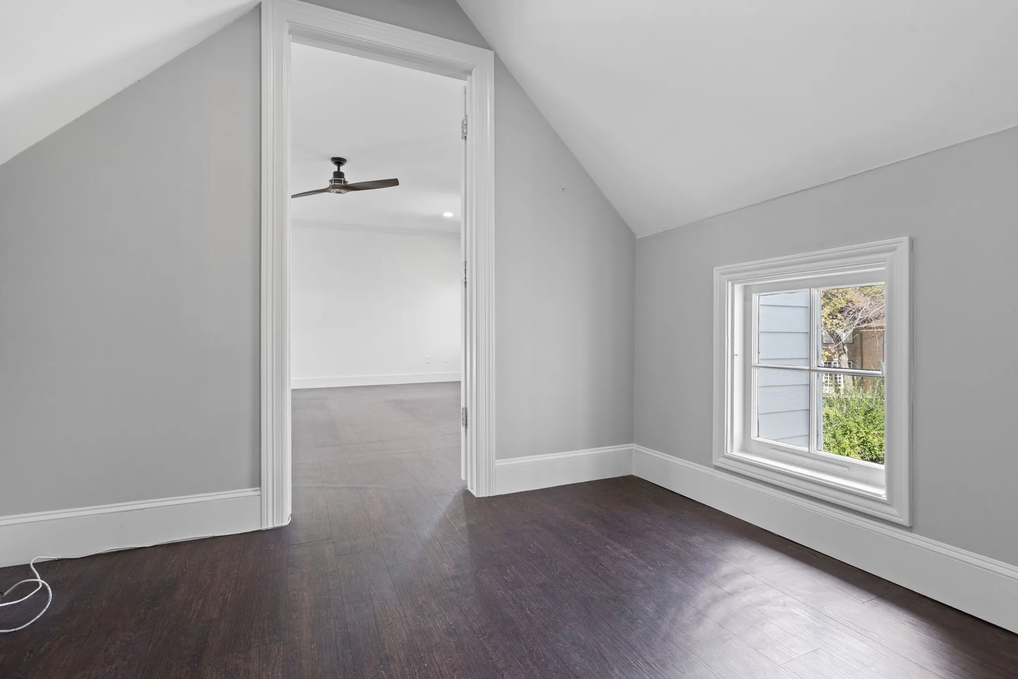 Bonus room with dark wood-style floors, lofted ceiling, and ceiling fan