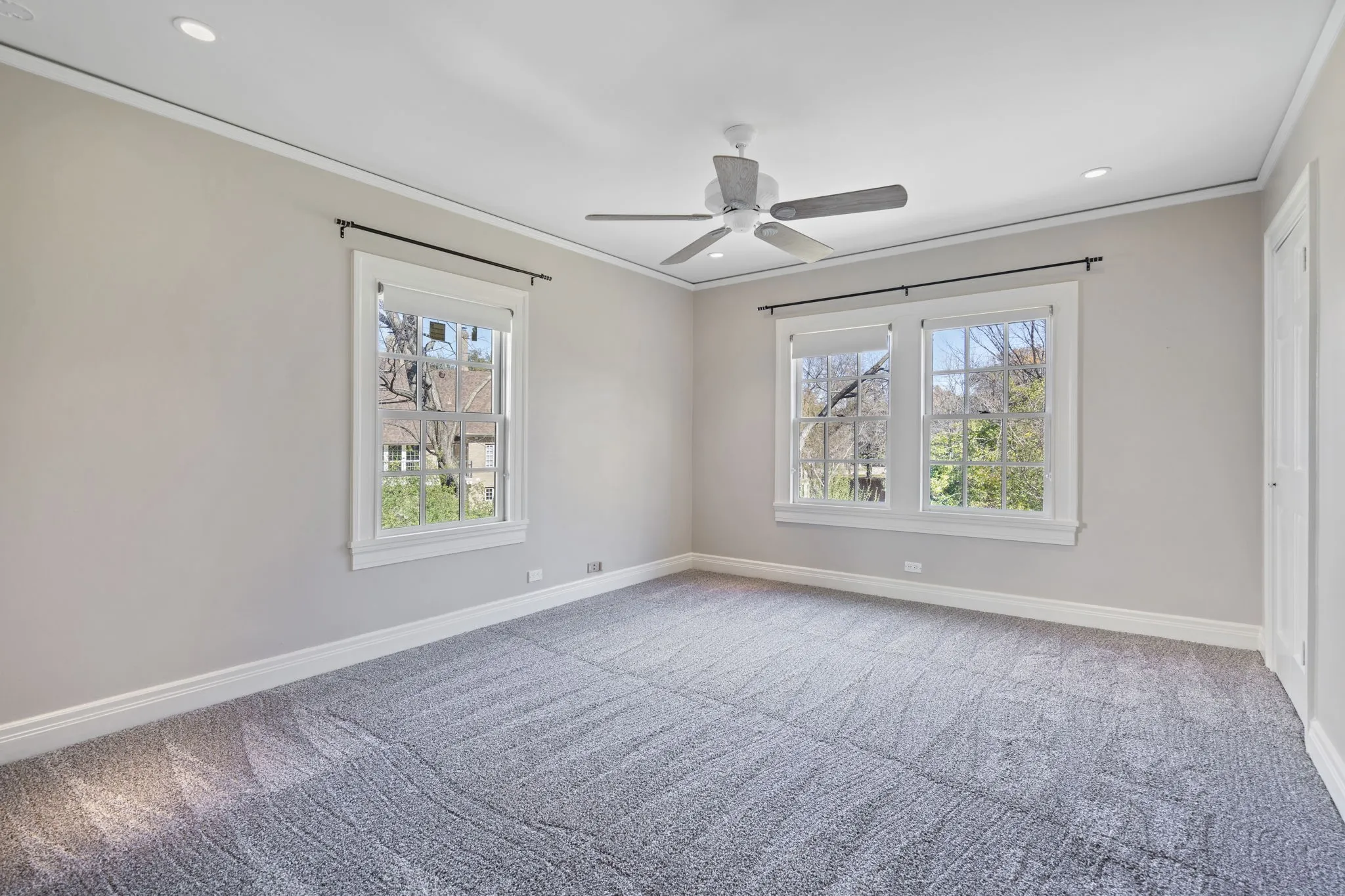 Empty room featuring light carpet, healthy amount of natural light, crown molding, a ceiling fan, and recessed lighting