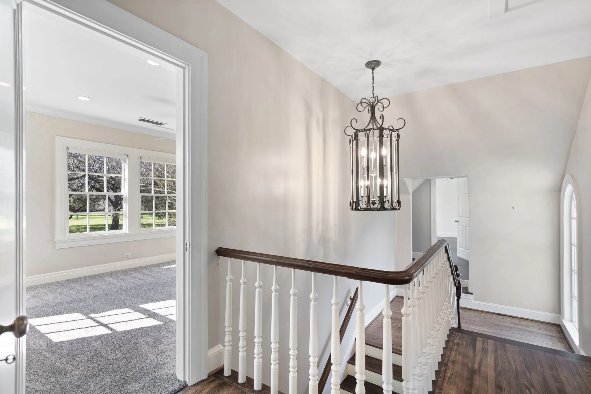 Stairs featuring a chandelier and wood finished floors