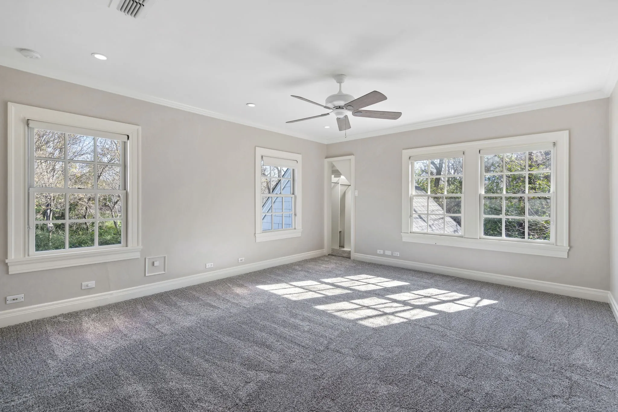 Carpeted empty room featuring crown molding, a ceiling fan, and recessed lighting