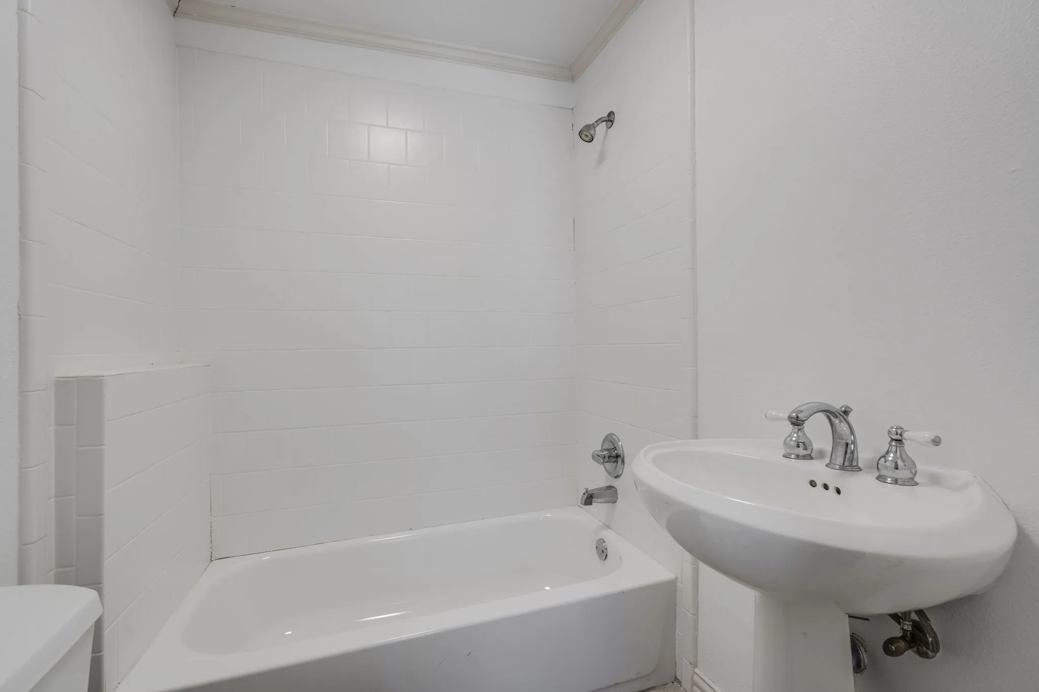 Full bathroom with bathtub / shower combination and ornamental molding