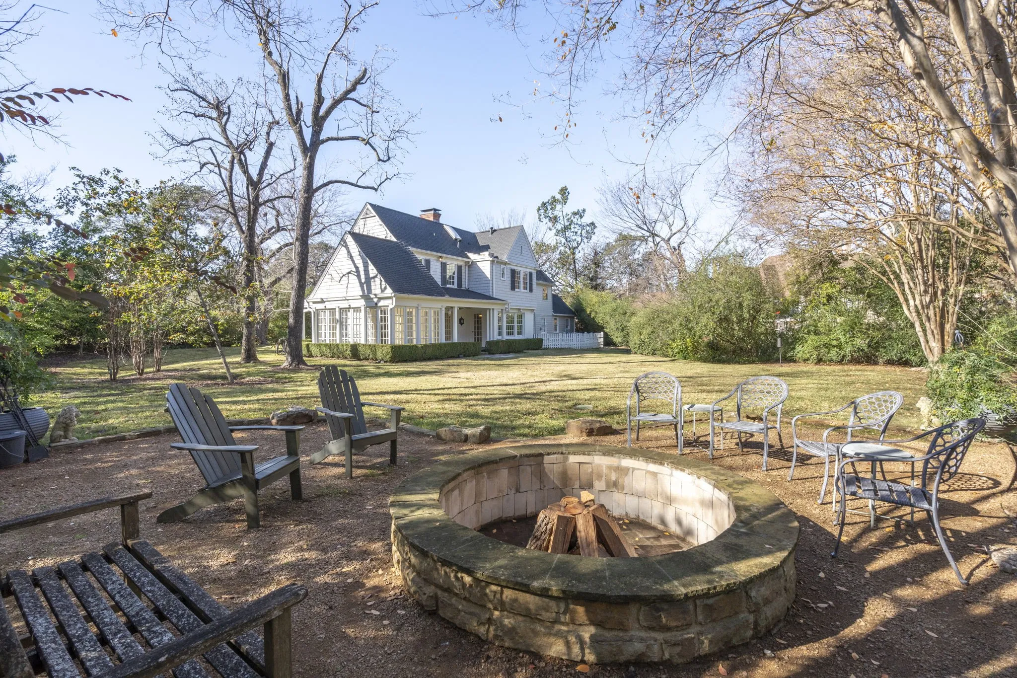 View of green lawn with a fire pit and a patio area