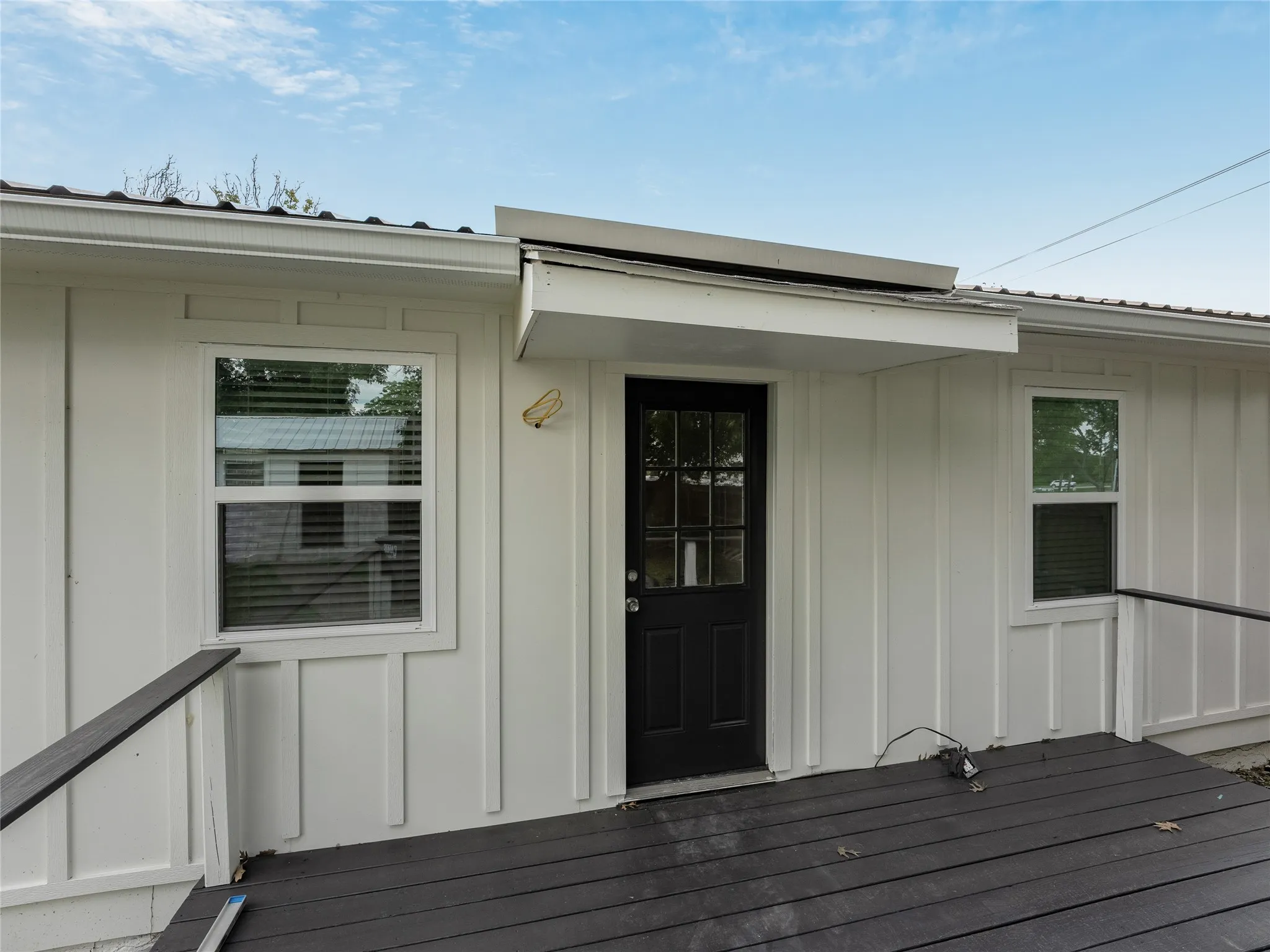 White board-and-batten siding with a dark metal roof
