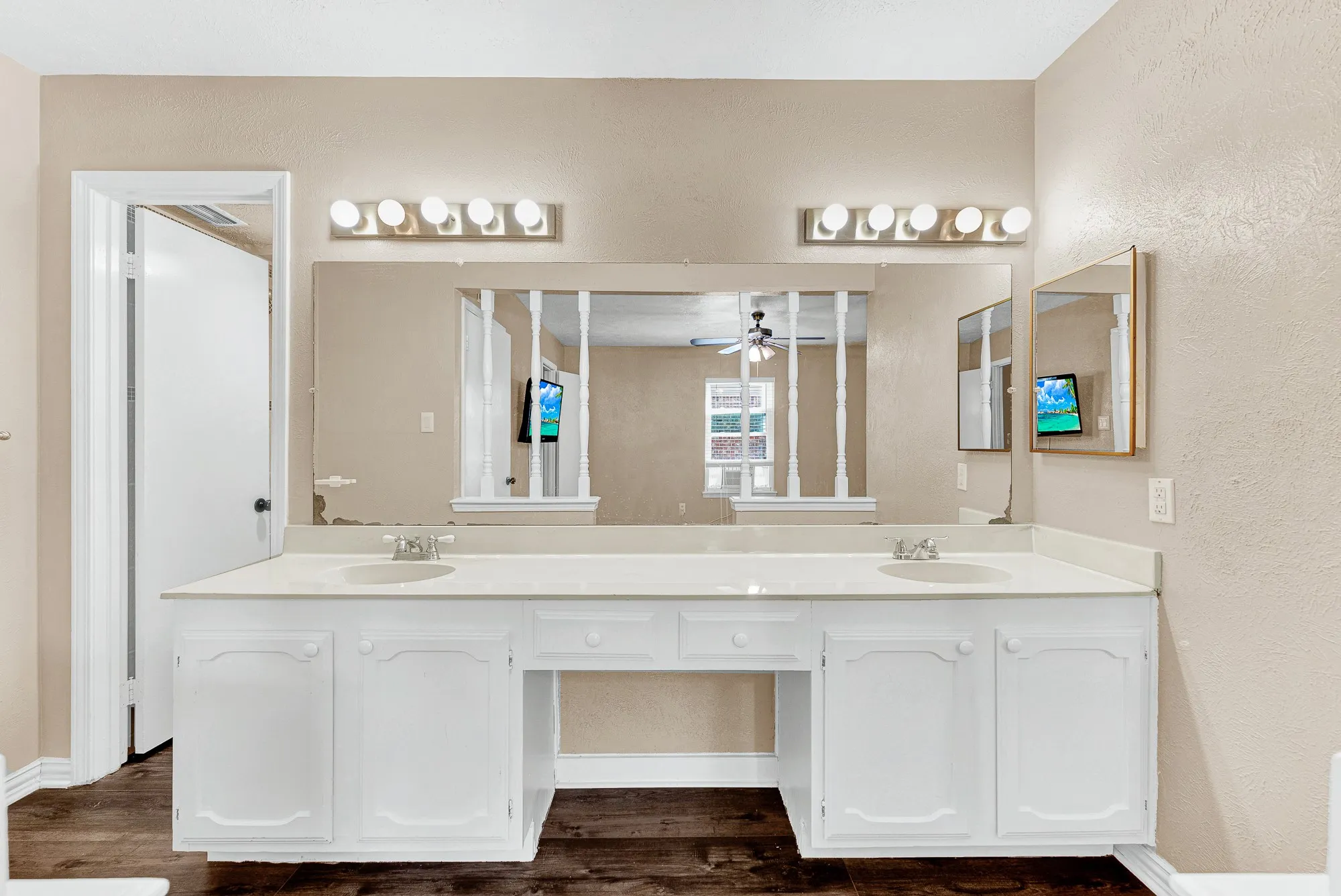 Walk-in shower with etched glass sliding doors, vanity with a white countertop and base cabinetry, wall-mounted mirror, and tile flooring