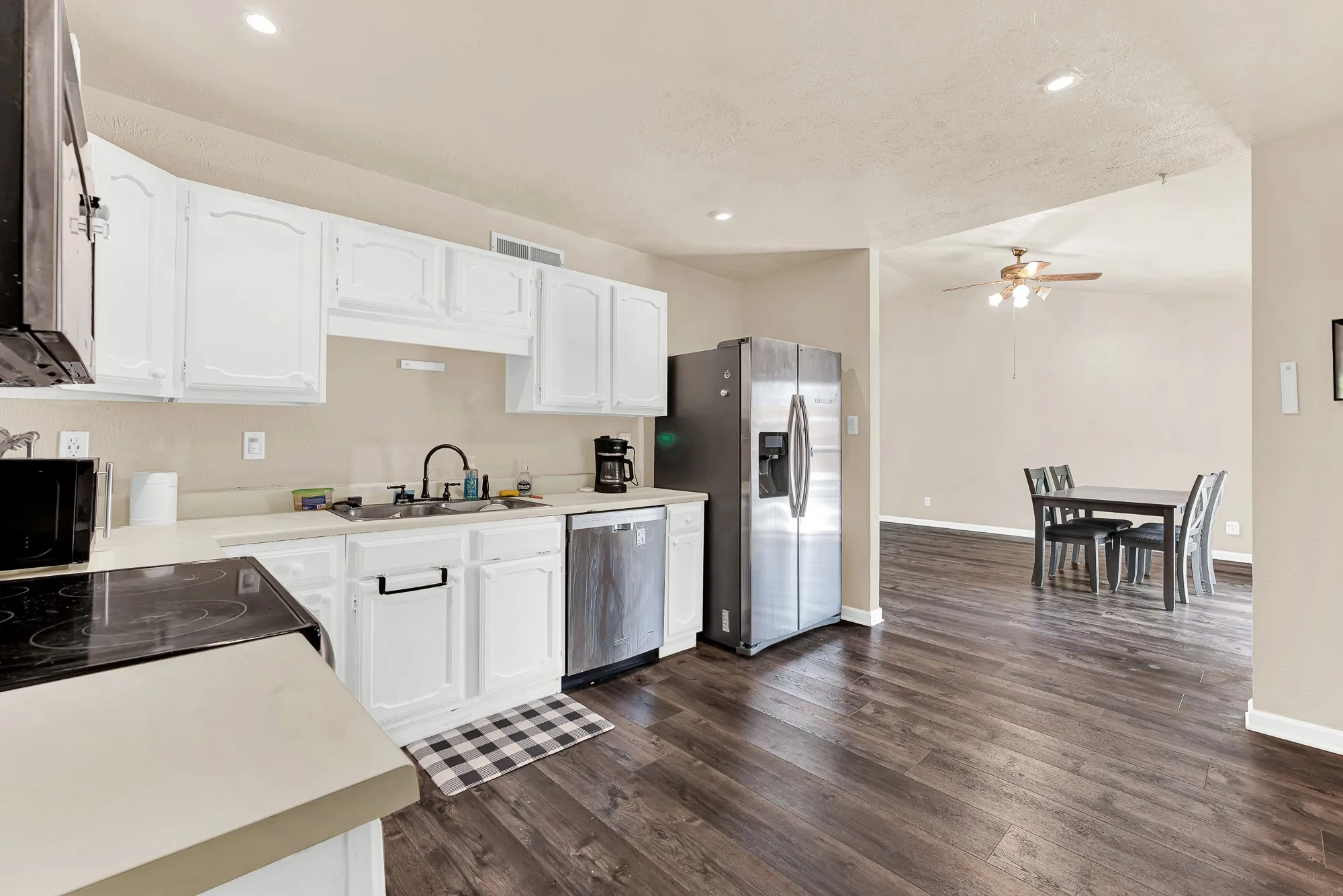 Kitchen featuring white cabinetry, stainless steel appliances, and light-toned countertops