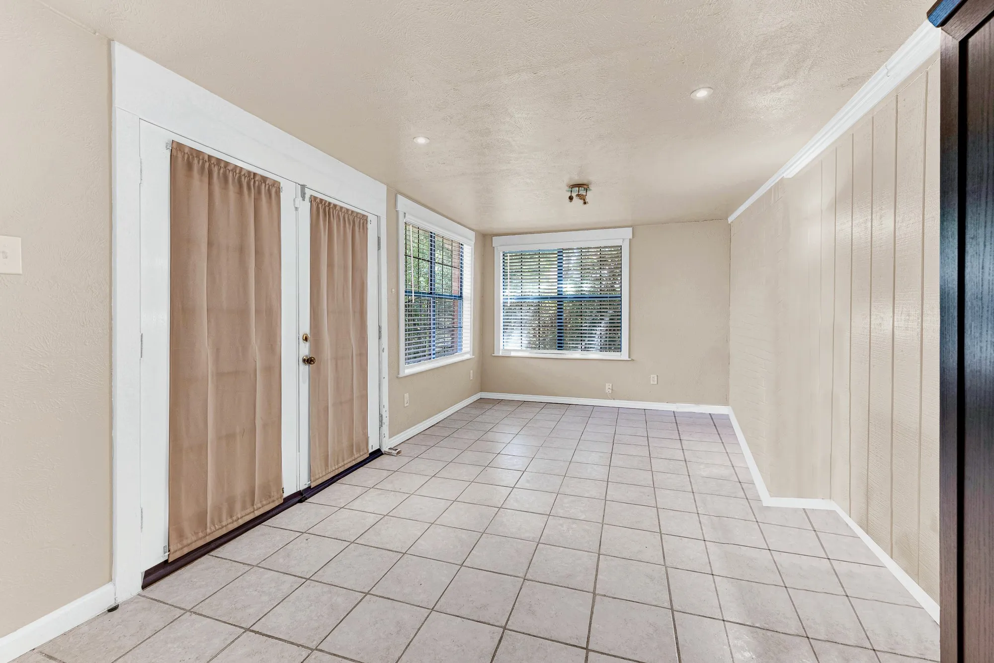 Vaulted ceilings with ceiling fans, wood-finish flooring, and white kitchen cabinetry with stainless steel appliances