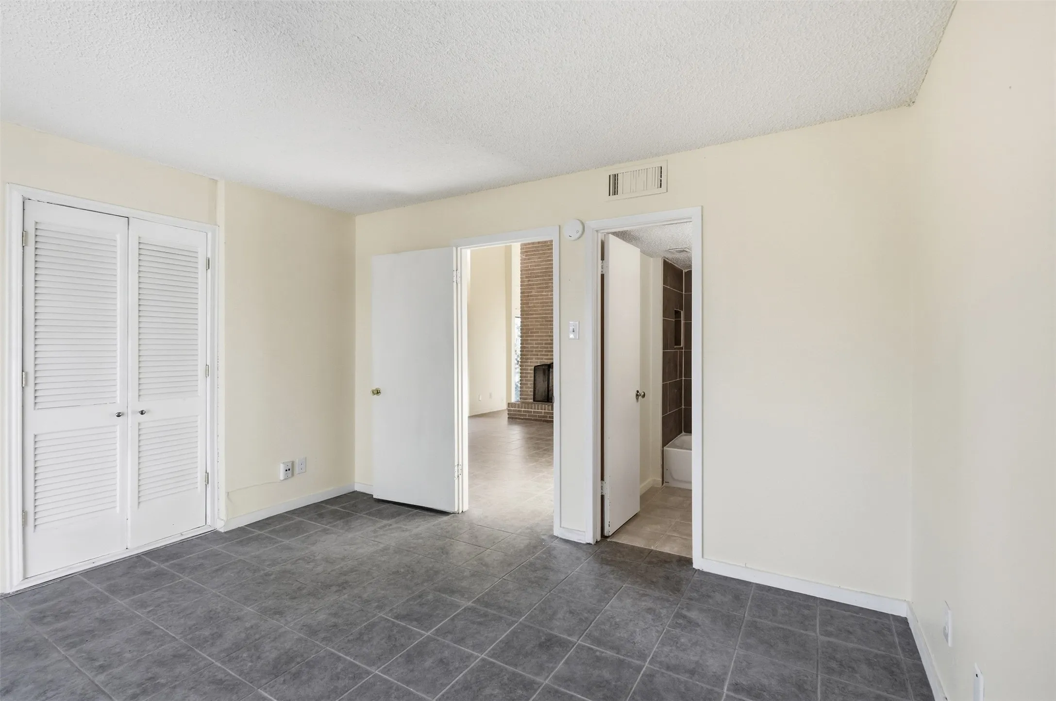 Gray tile flooring throughout, with white louvered bifold doors