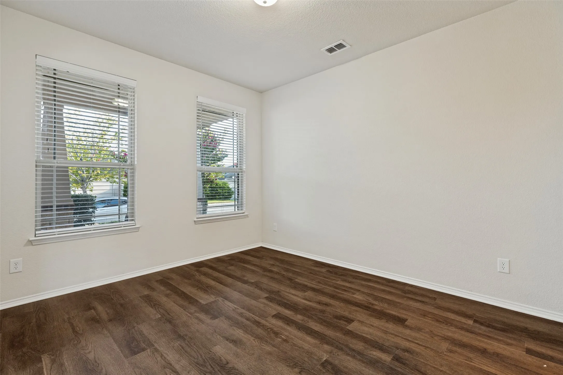Wood-finish flooring with white baseboards and light-toned walls