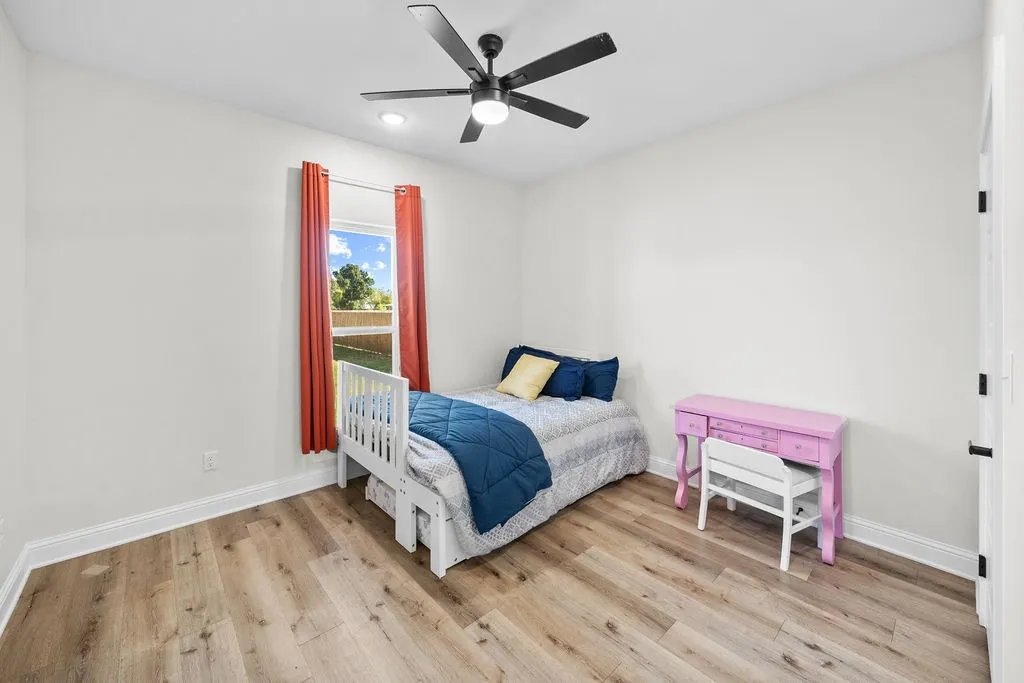 Recessed lighting, wood-finish flooring, ceiling fan, white trim, and a window