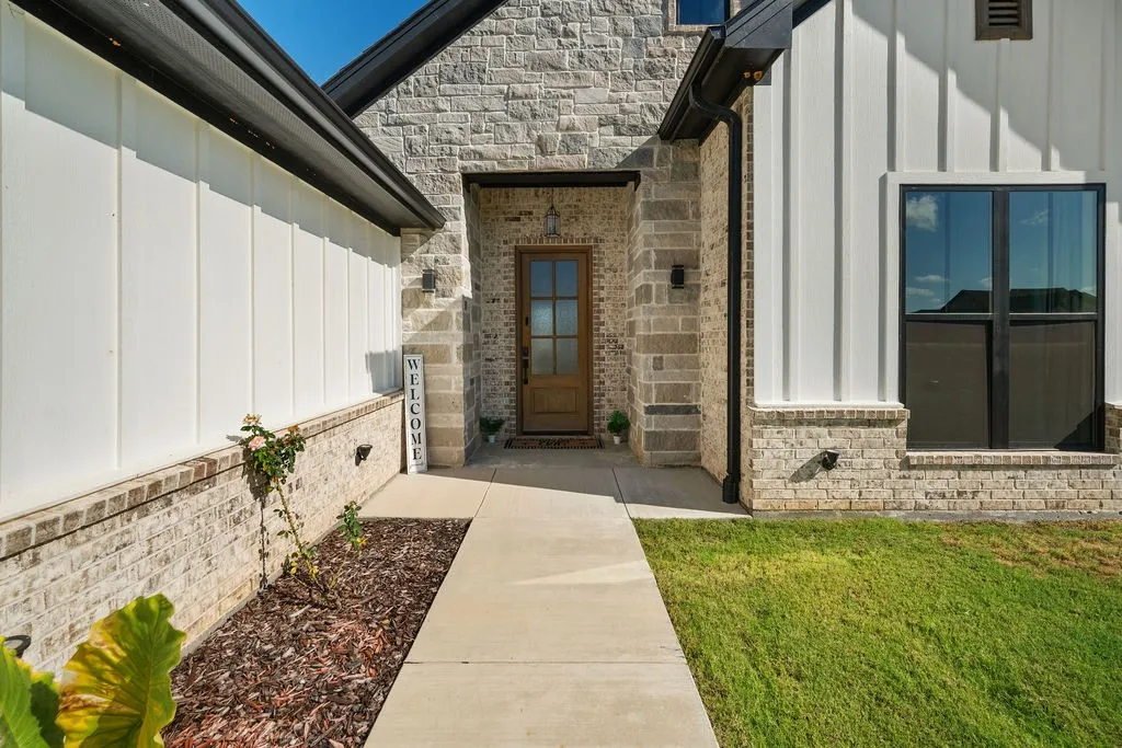 Stone and board-and-batten exterior with a wood-panel front door