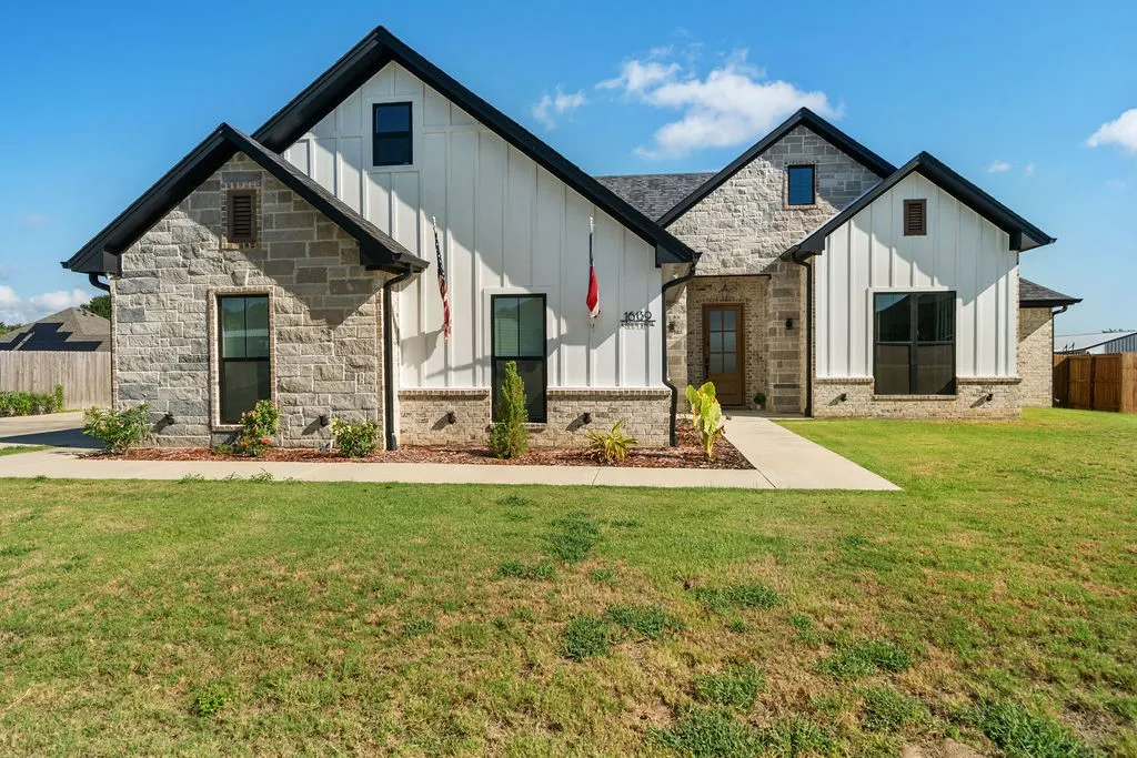 Stone and vertical white siding exterior with dark trim