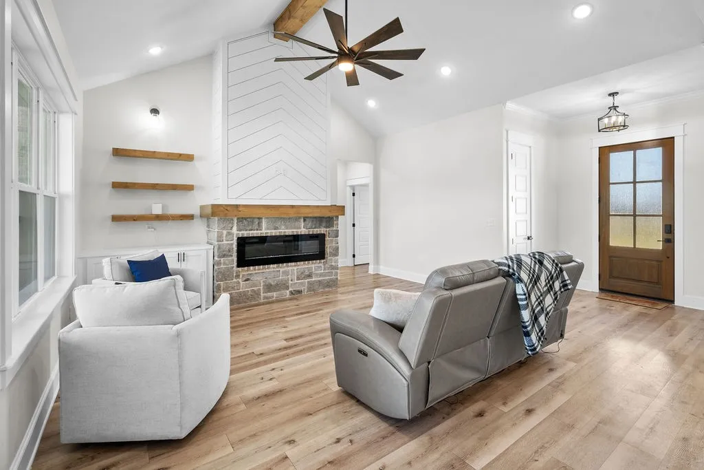 Vaulted ceiling with an exposed wood beam, contemporary ceiling fan, and recessed lighting