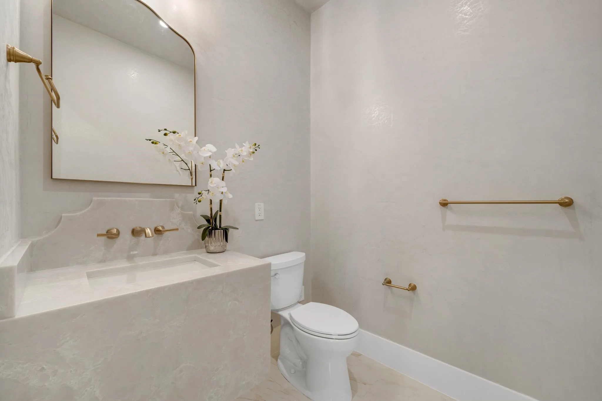 Integrated vanity with a rectangular sink, wall-mounted faucet, and a decorative mirror