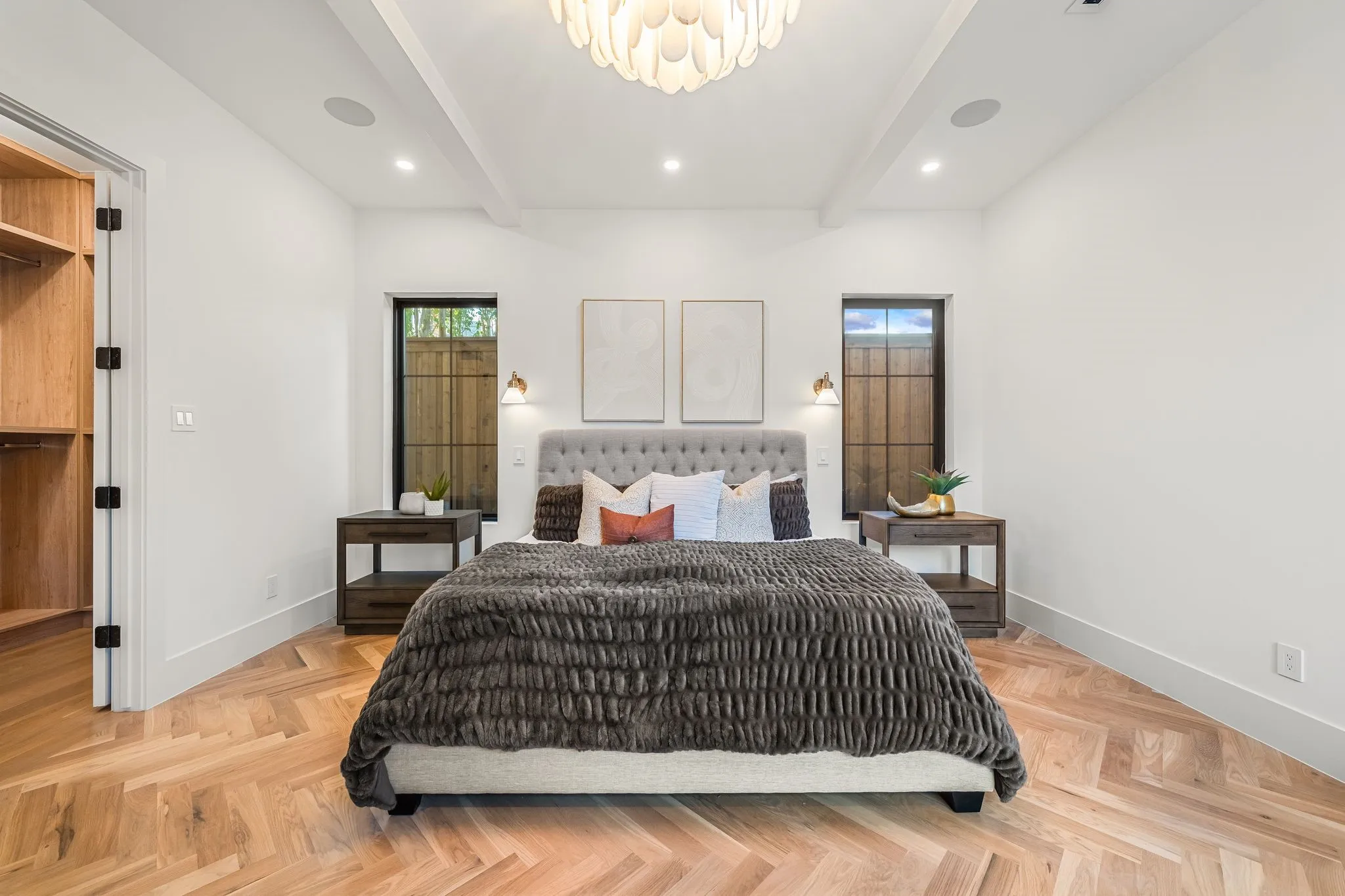 Herringbone wood-finish flooring, vaulted ceiling with exposed beams, built-in recessed lighting, and a custom built-in closet with wood shelving