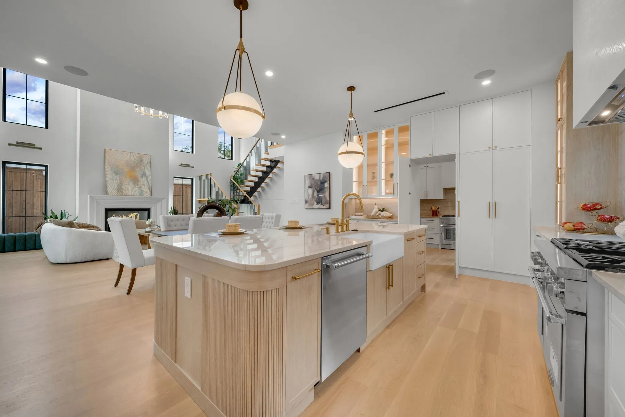 Gourmet kitchen with a large central island, farmhouse sink, and integrated appliances