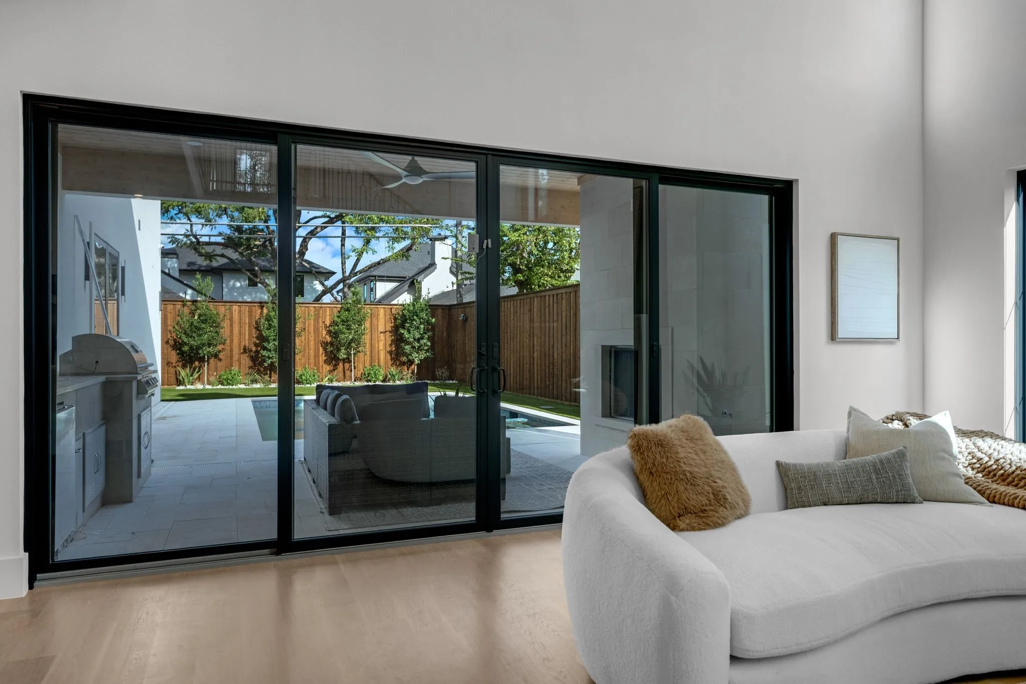 Expansive multi-panel sliding glass doors with dark frames, wood-finish flooring, and a neutral wall color