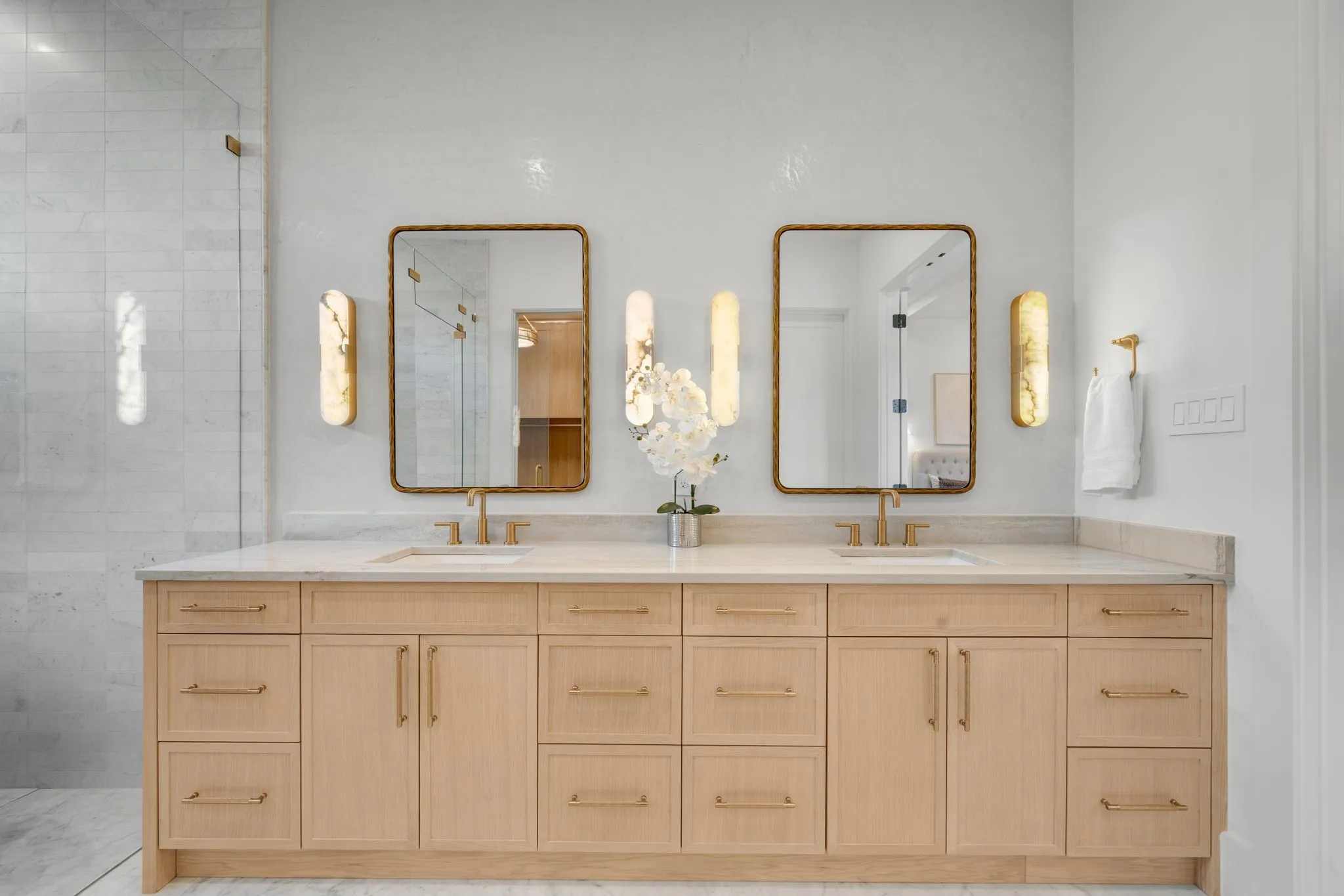 Dual vanity with light wood-finish cabinetry, integrated sinks, and individual rectangular mirrors