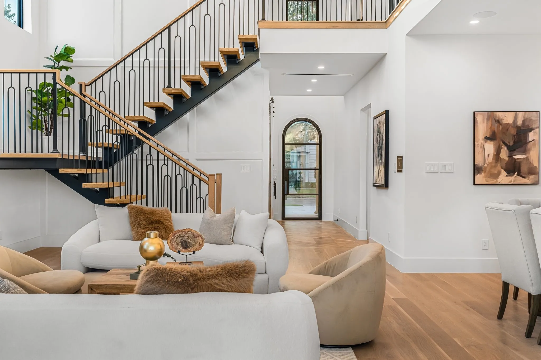 Open-tread staircase with custom black metal balusters and wood handrails