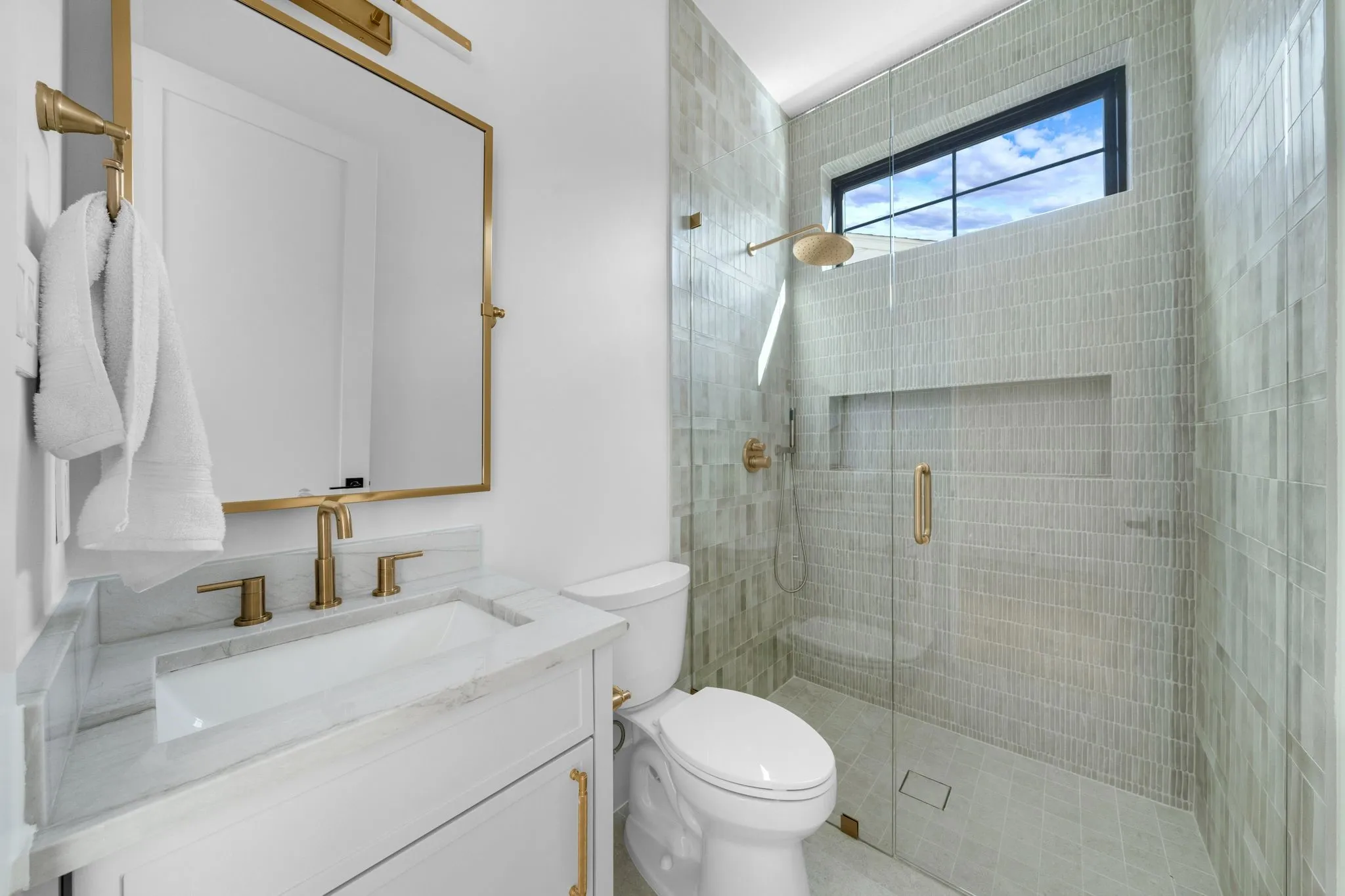 White vanity with a rectangular undermount sink and stone countertop