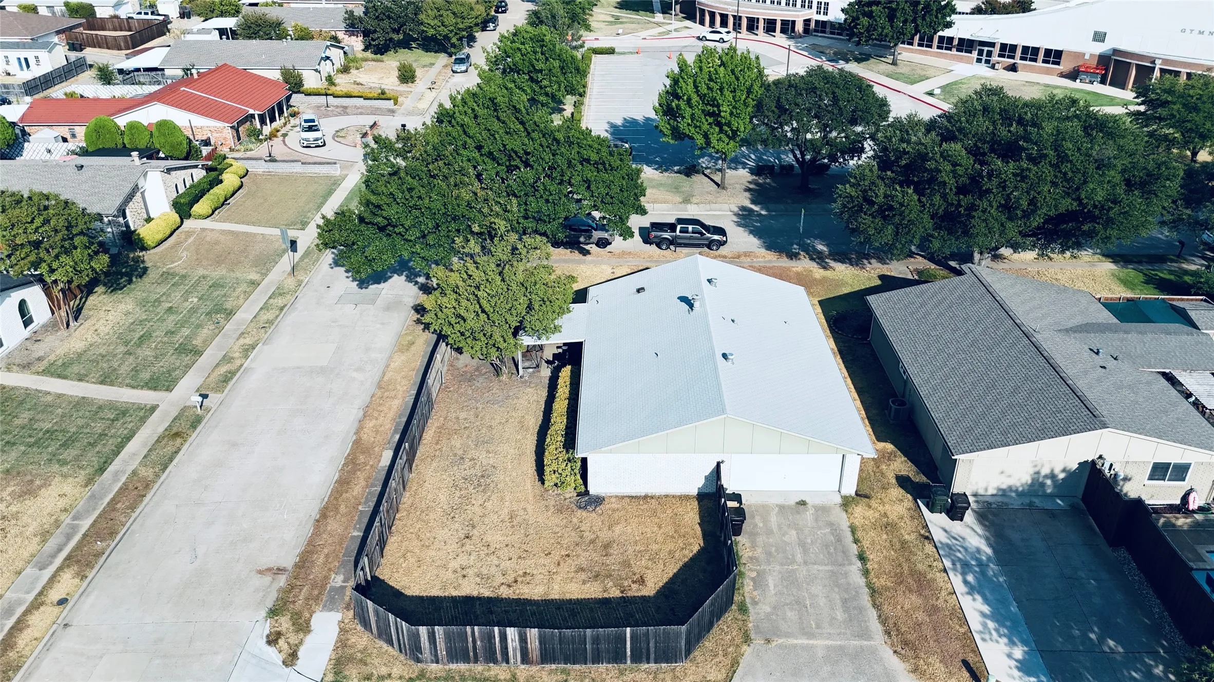 Single-story residence with an attached two-car garage, concrete driveway, and a wood privacy fence