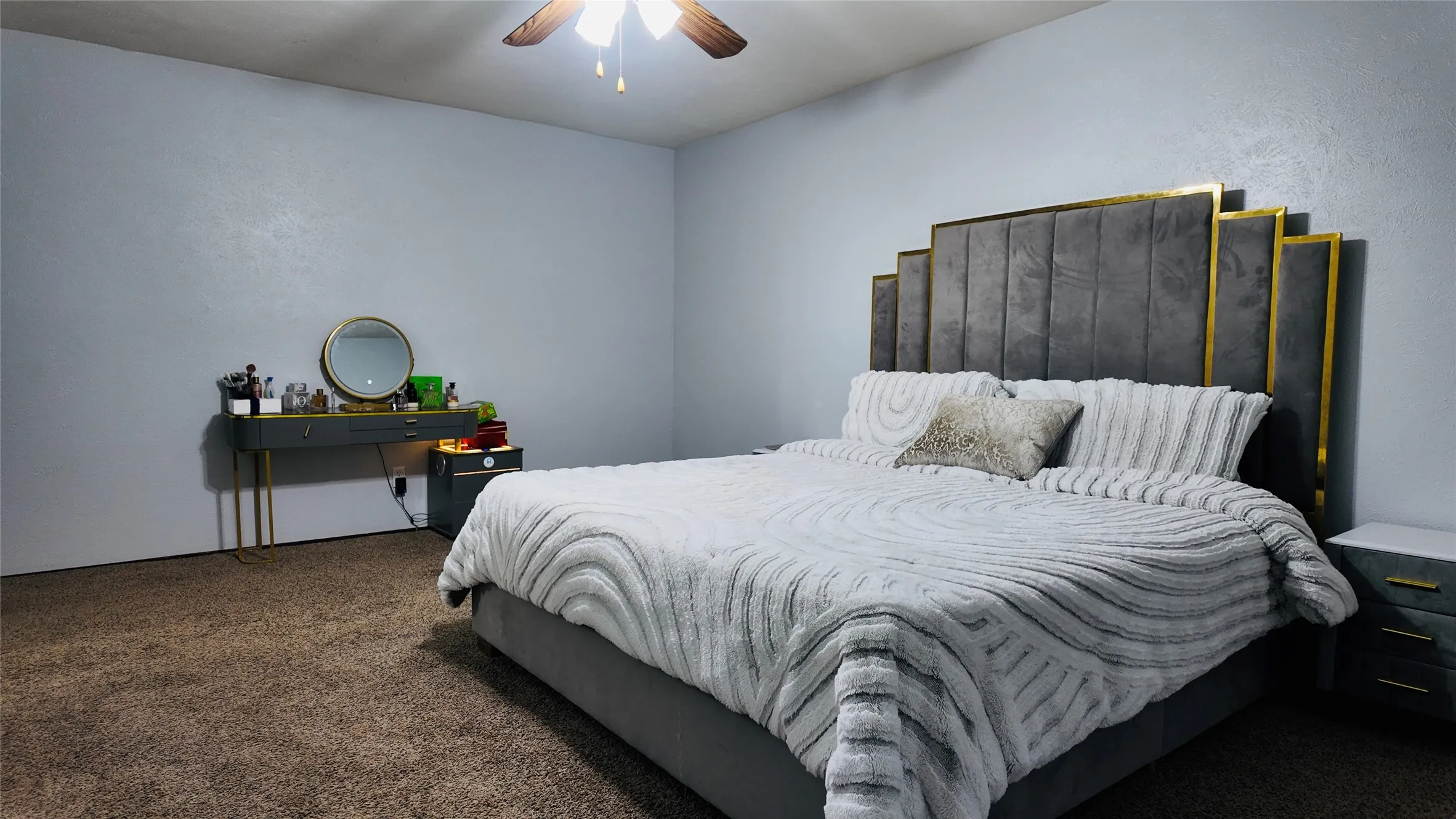 Textured wall finishes with a ceiling-mounted fan and light fixture