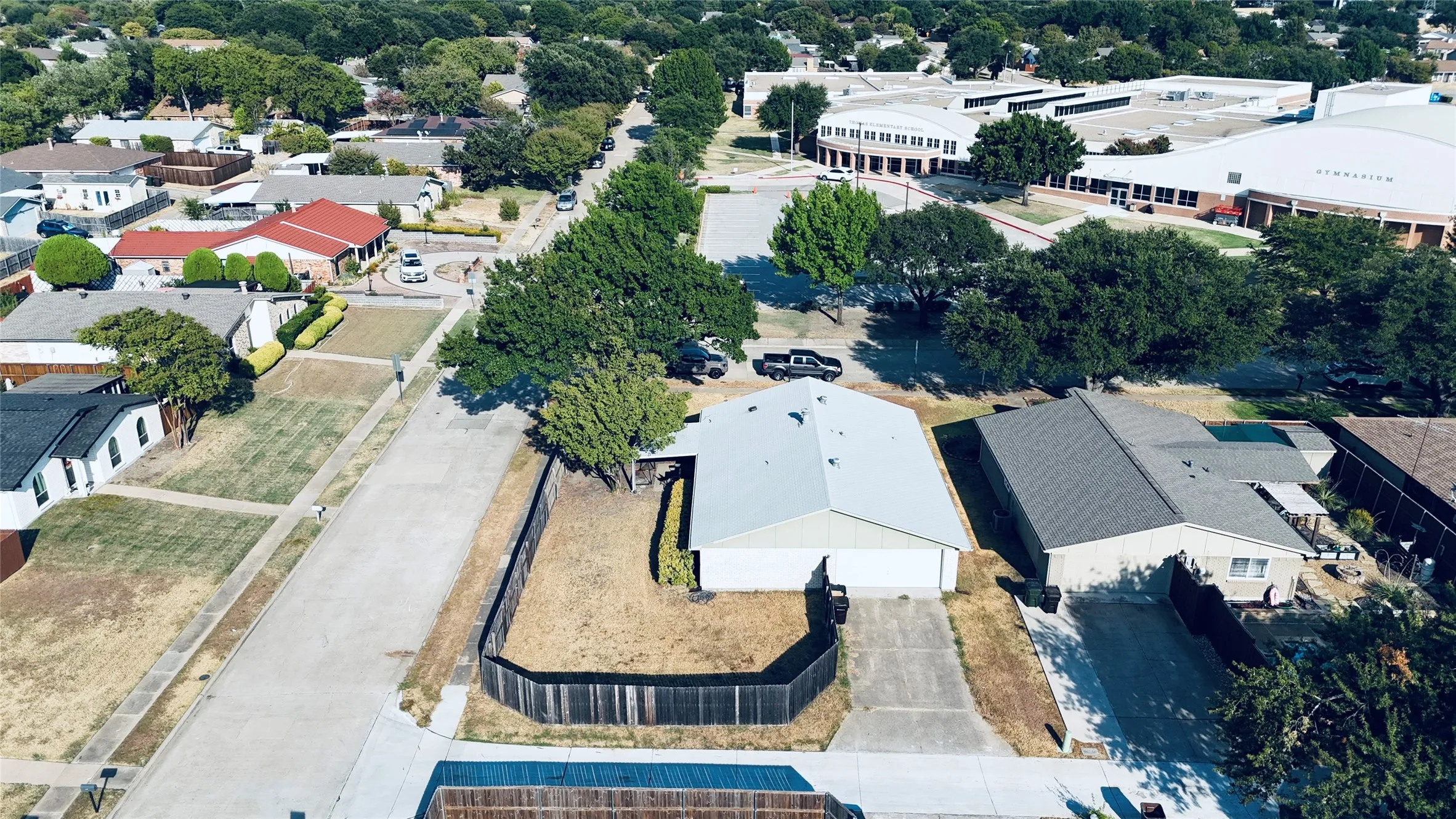 Single-story residence with an attached two-car garage, concrete driveway, and fenced backyard