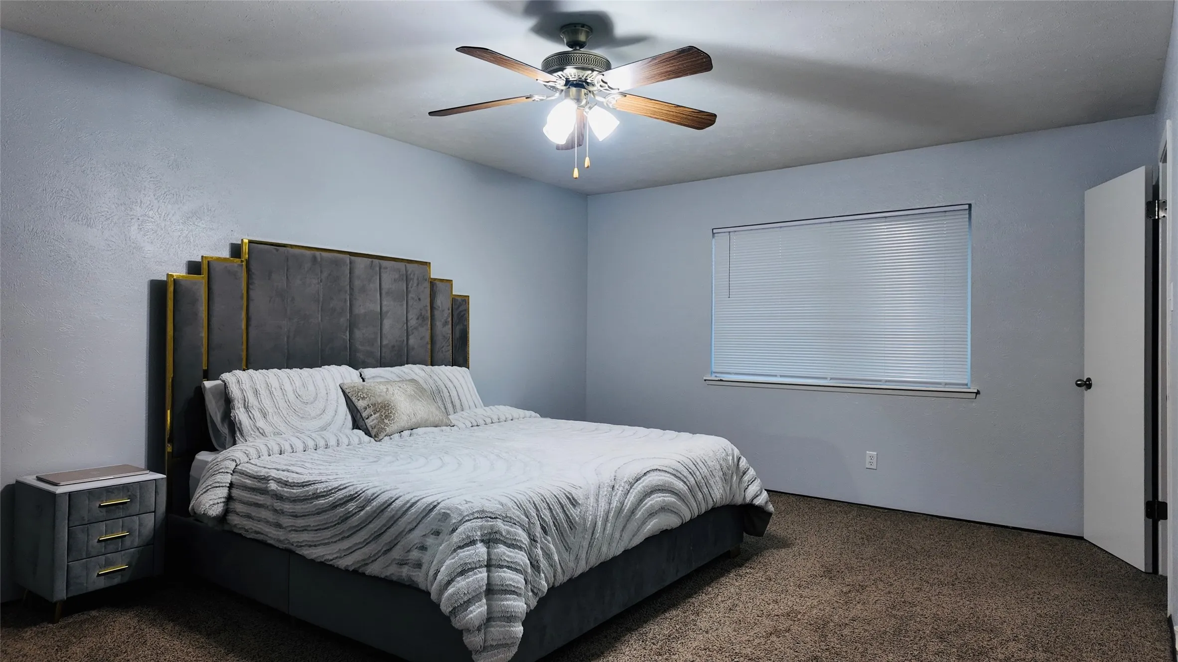 Ceiling fan with light fixture, window with blinds, and wall-to-wall carpeting