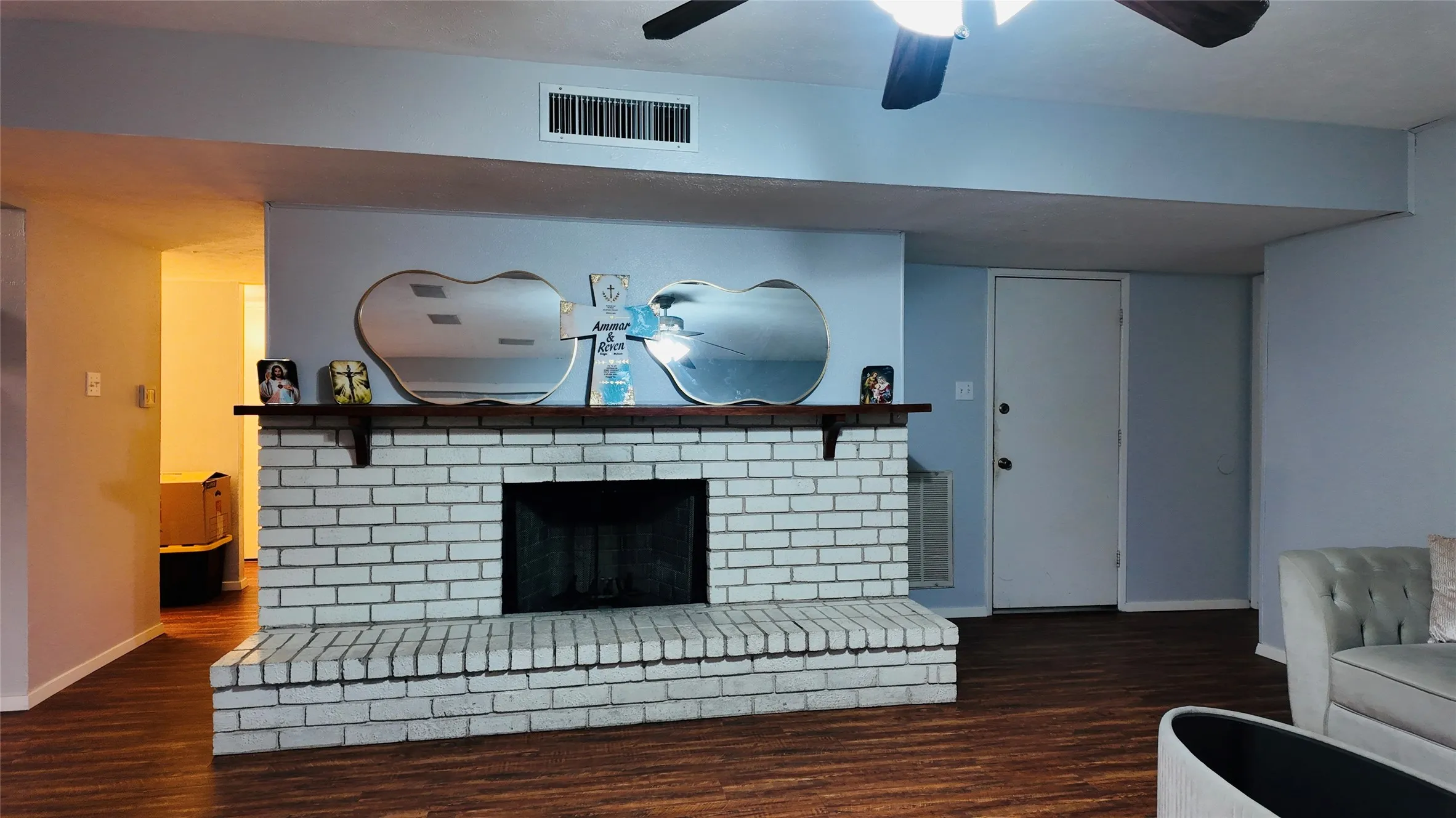 White brick fireplace with a wood-finish mantel and hearth