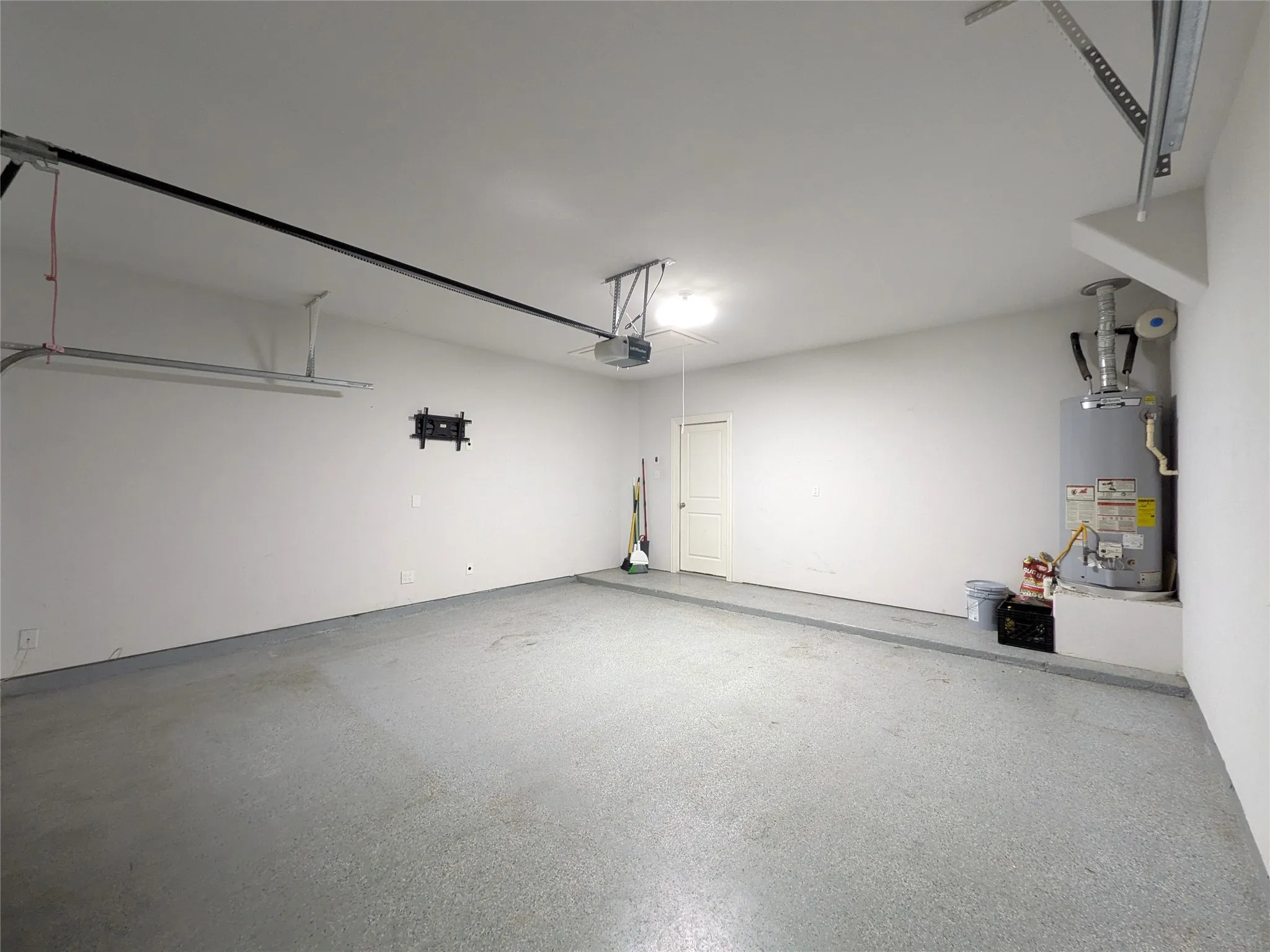 Spacious garage featuring a finished floor and white walls